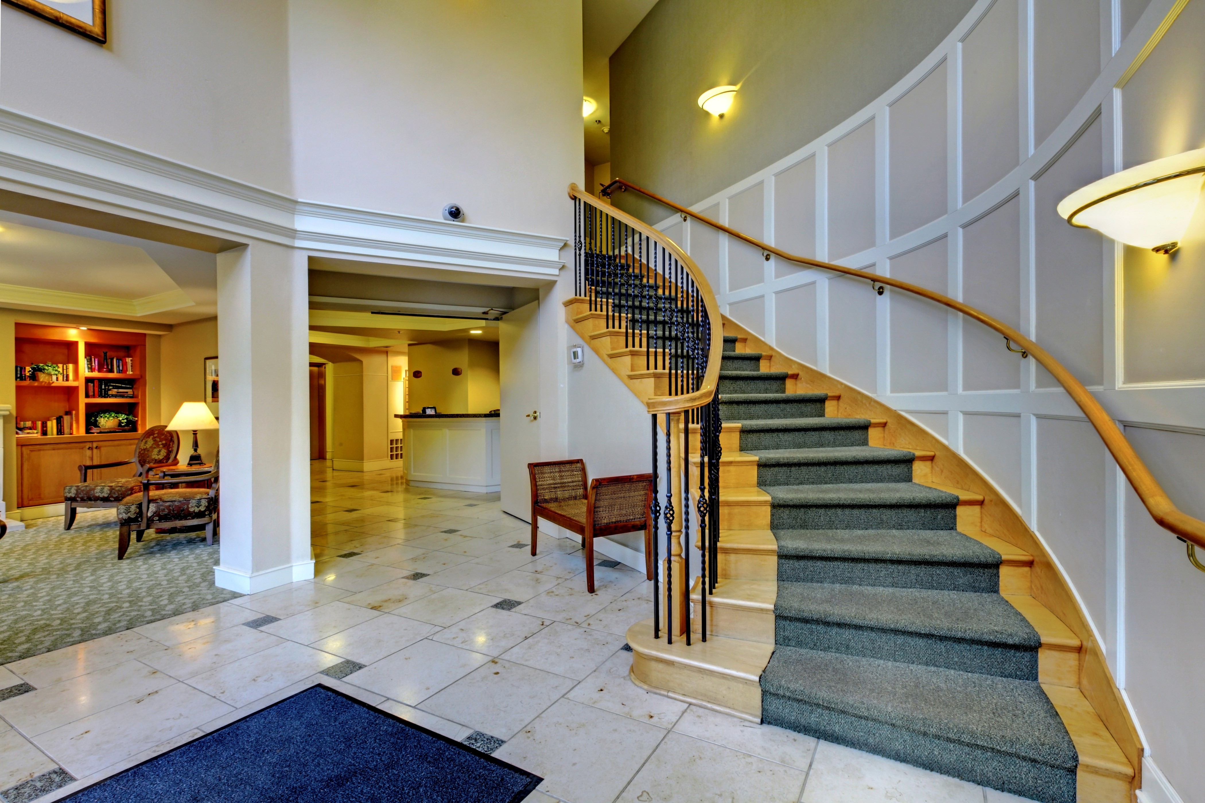 Interior design of a lobby with a curved staircase HD Wallpaper