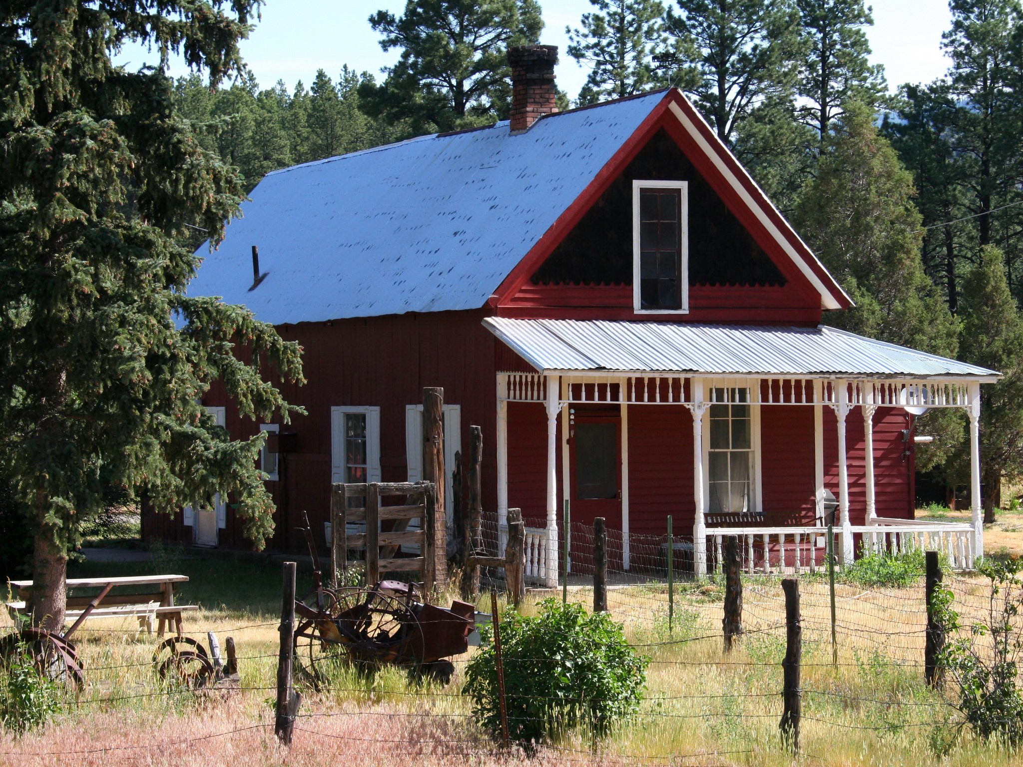 Red wooden house with a porch and trees HD Wallpaper