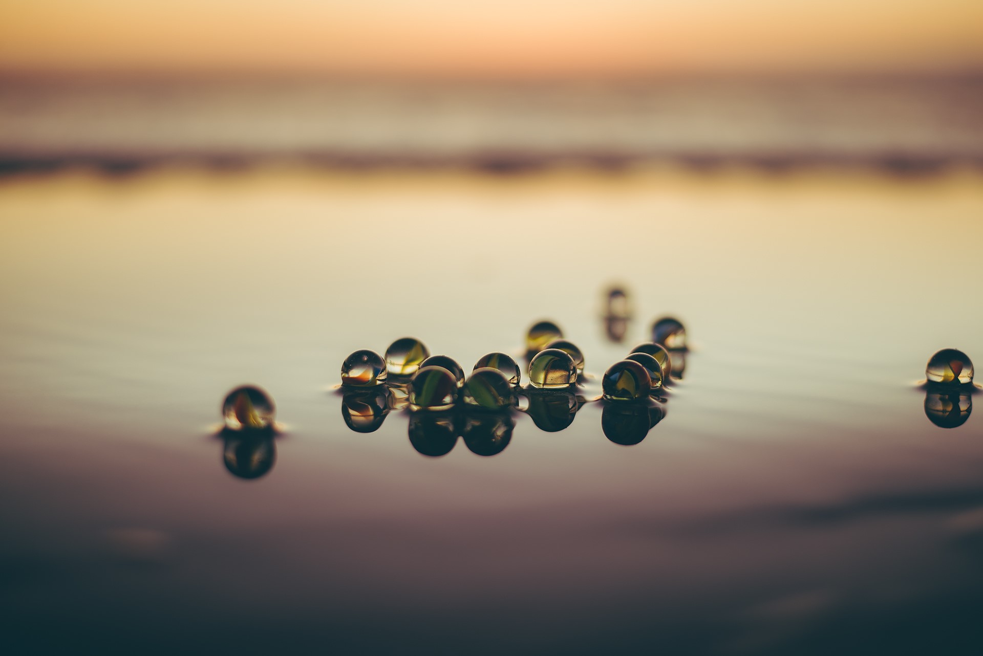 Marbles floating on water at sunset HD Wallpaper