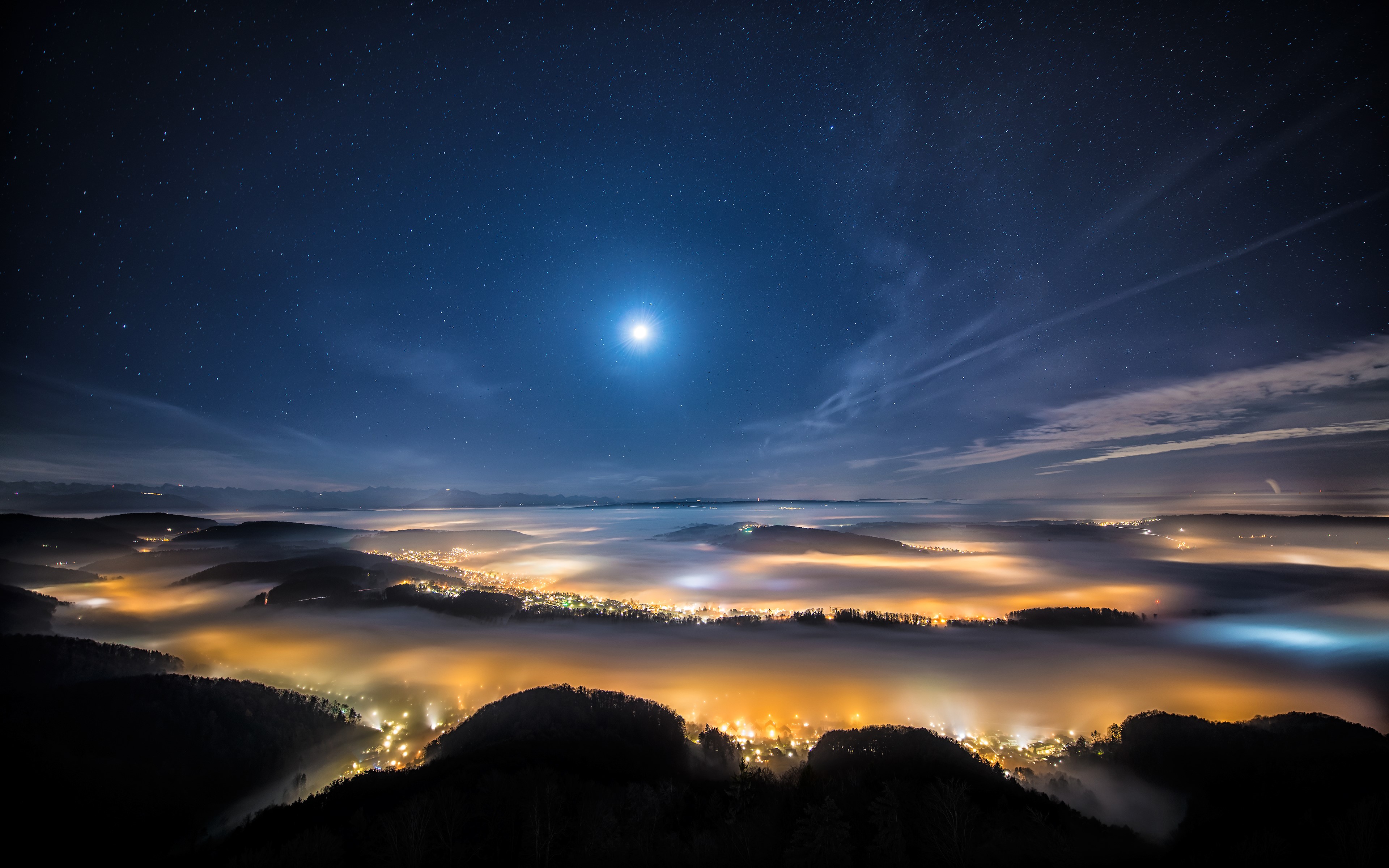 Night sky over a foggy valley with city lights HD Wallpaper