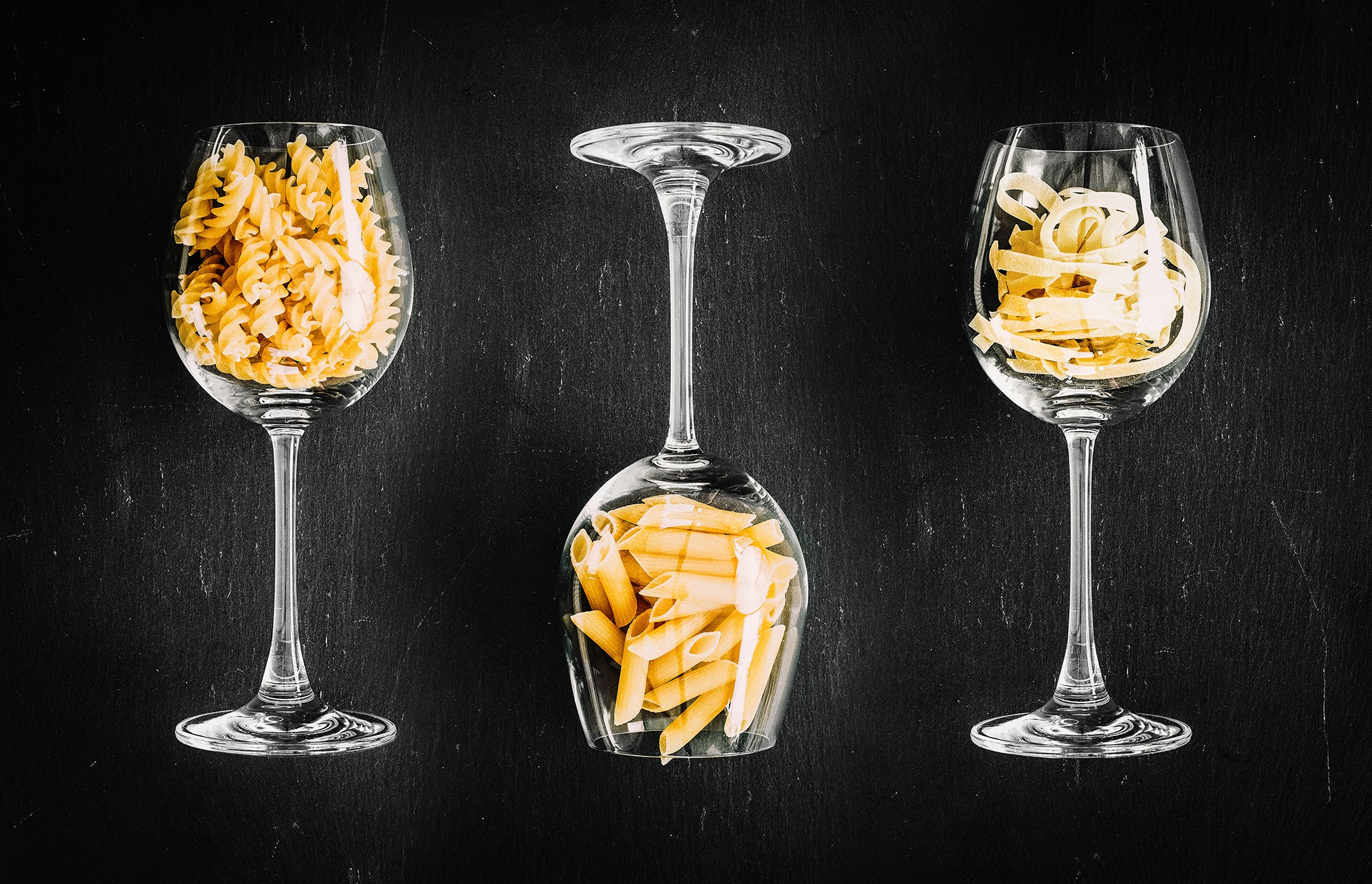 Three wine glasses filled with pasta on a dark background HD Wallpaper