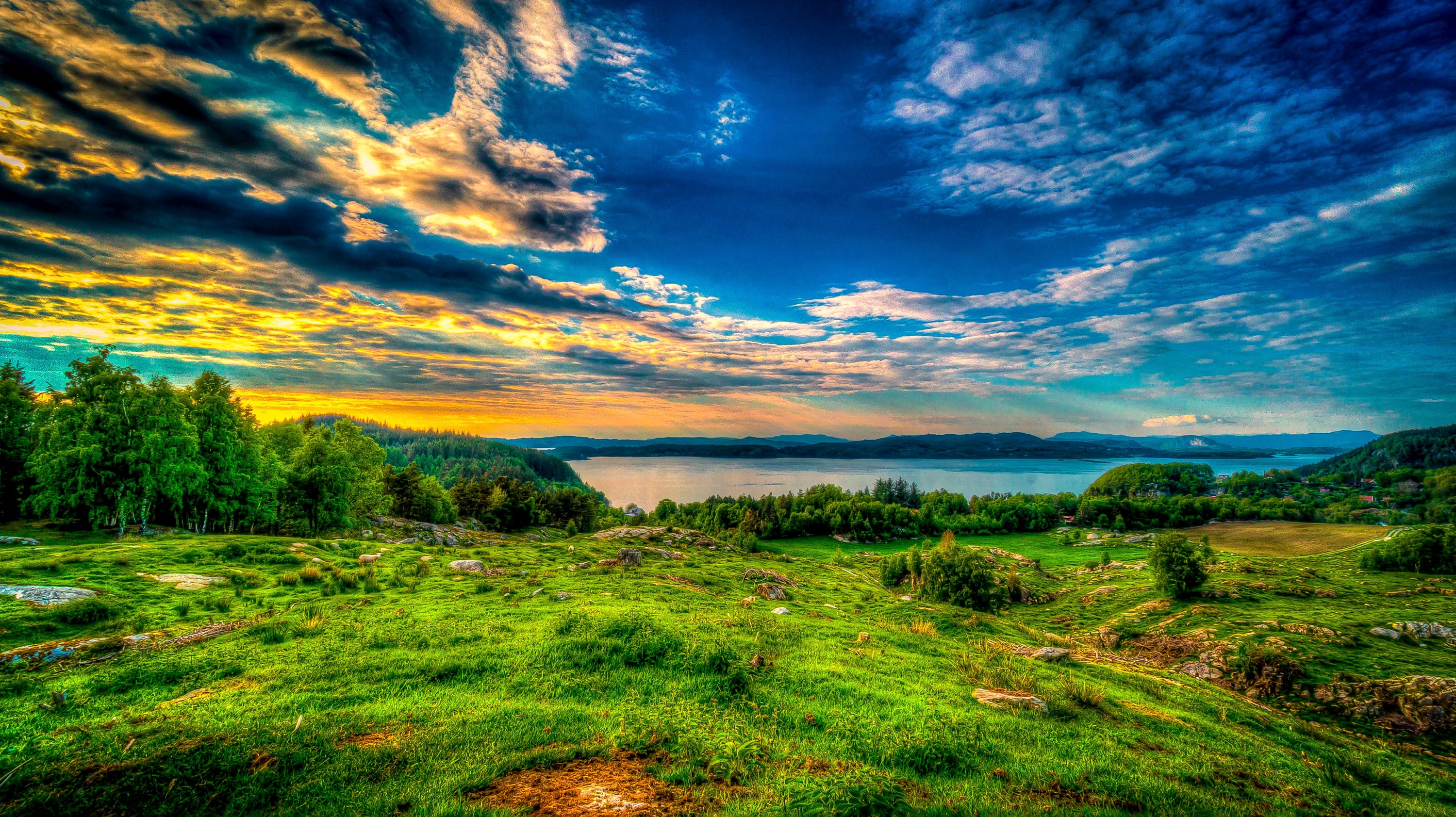 Lake and green hills under a dramatic sky HD Wallpaper