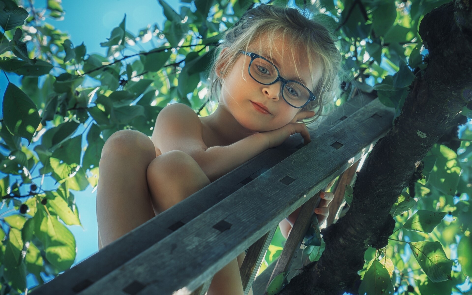 Young girl with glasses in a tree HD Wallpaper