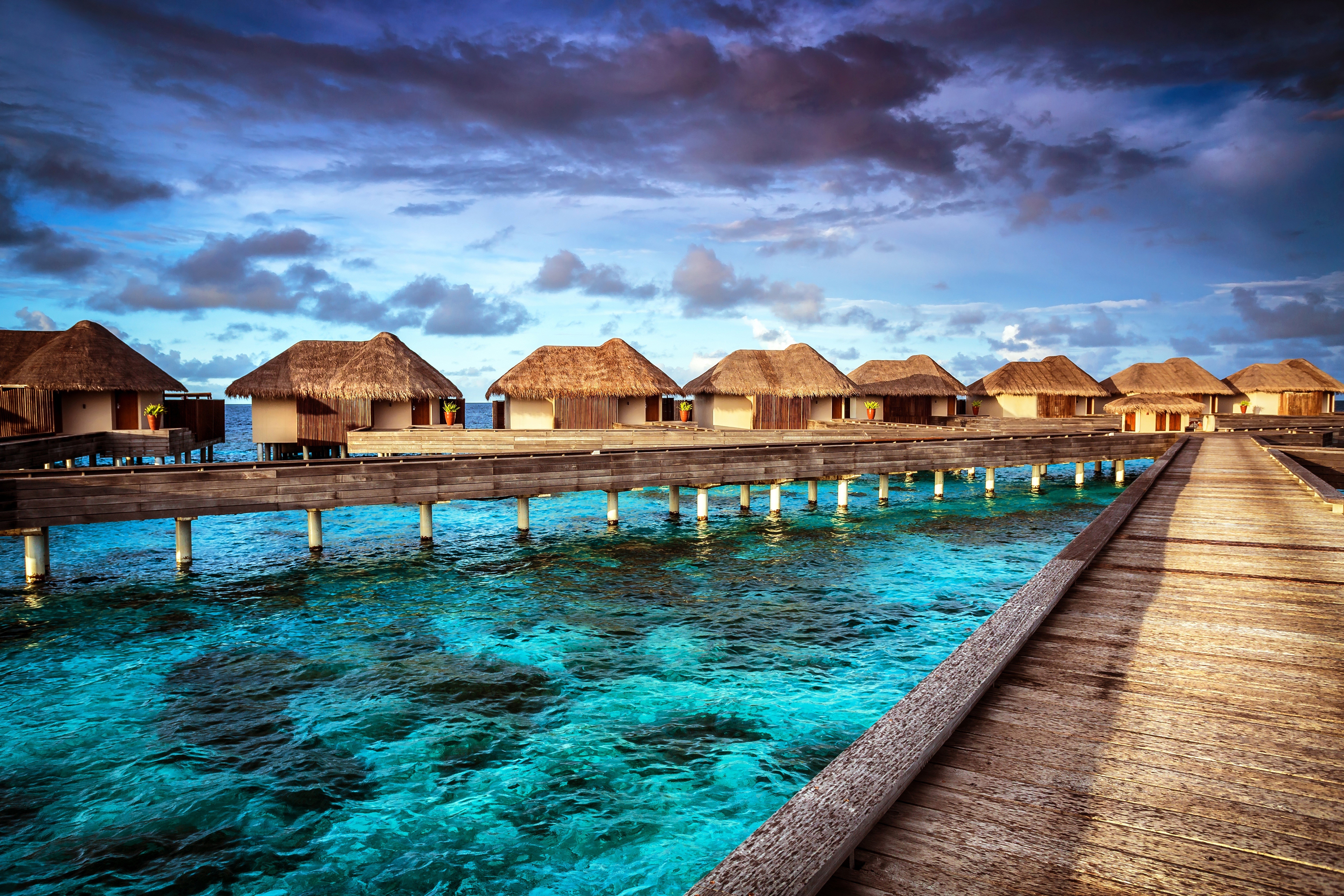Overwater bungalows on a wooden pier in the tropics HD Wallpaper