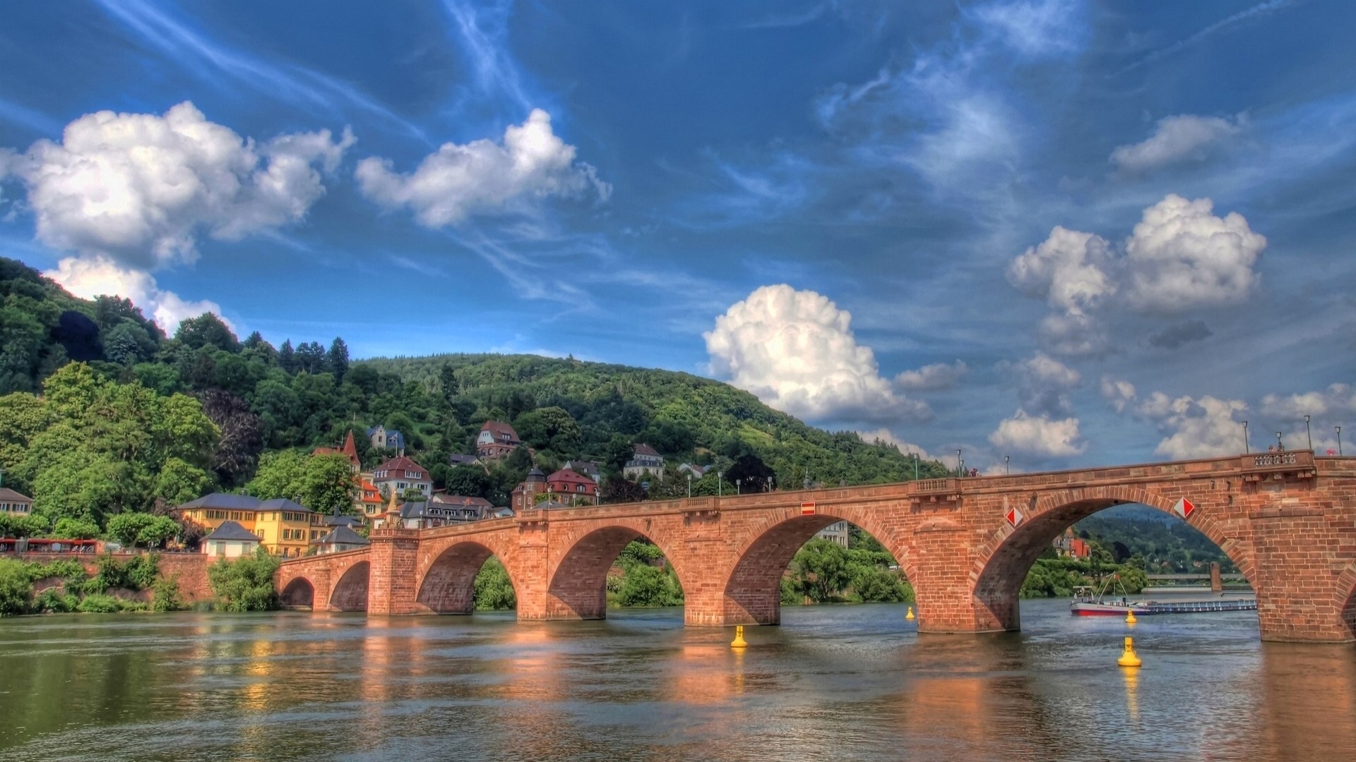 Stone bridge over a river with green hills and blue sky HD Wallpaper
