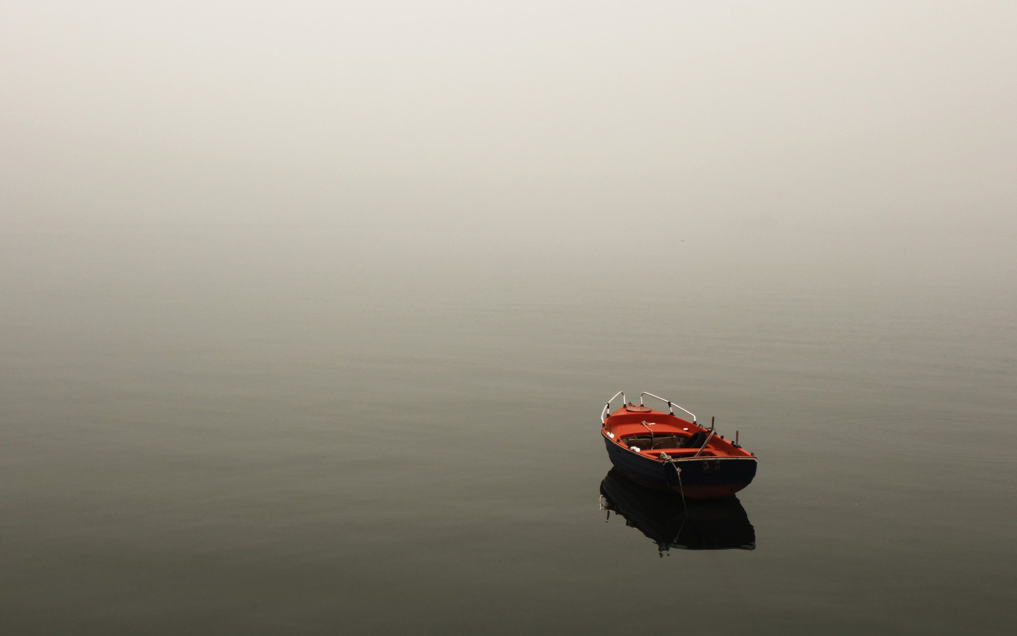 A lone boat in the fog on a lake HD Wallpaper