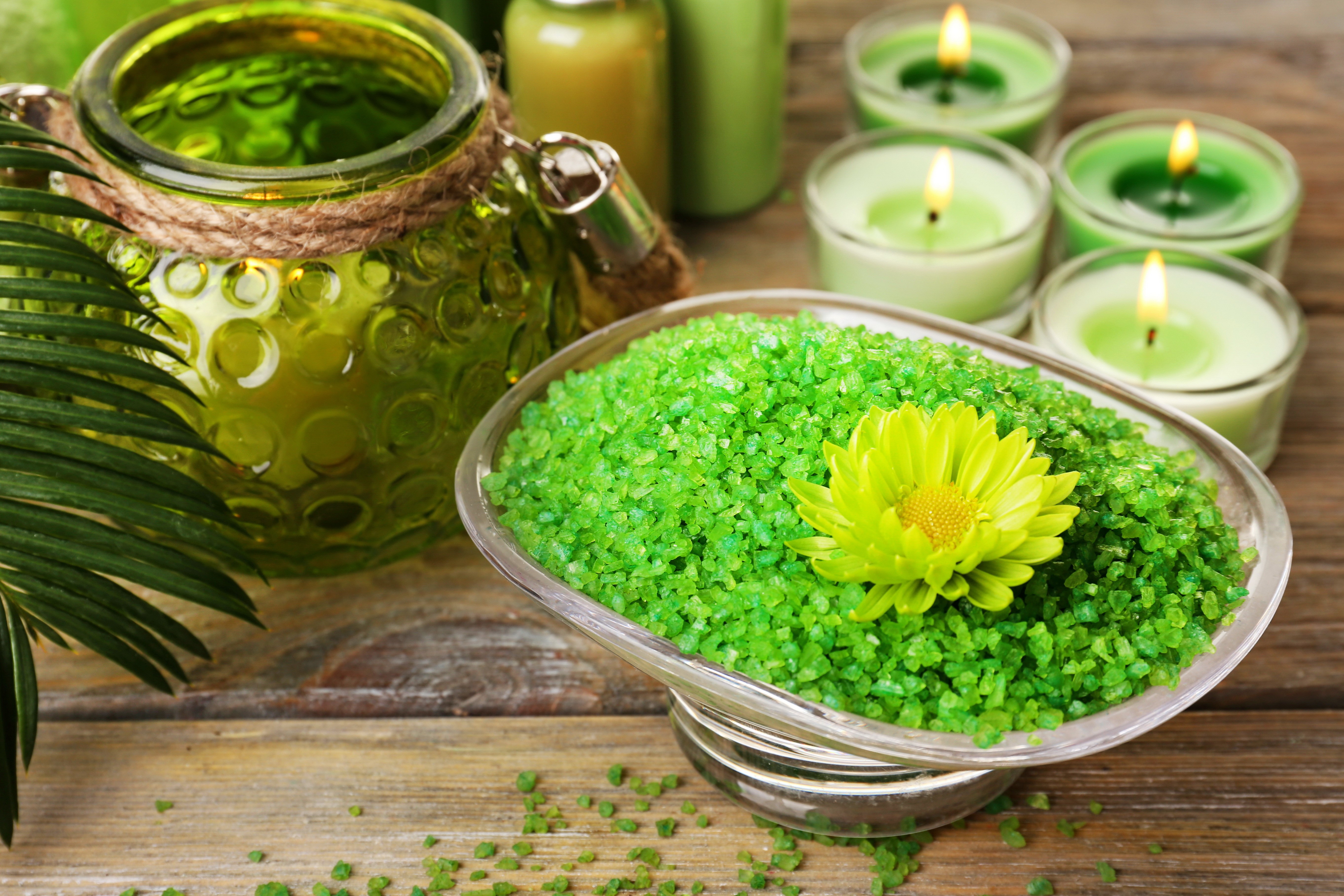 Spa setting with green bath salts, candles, and a glass jar HD Wallpaper