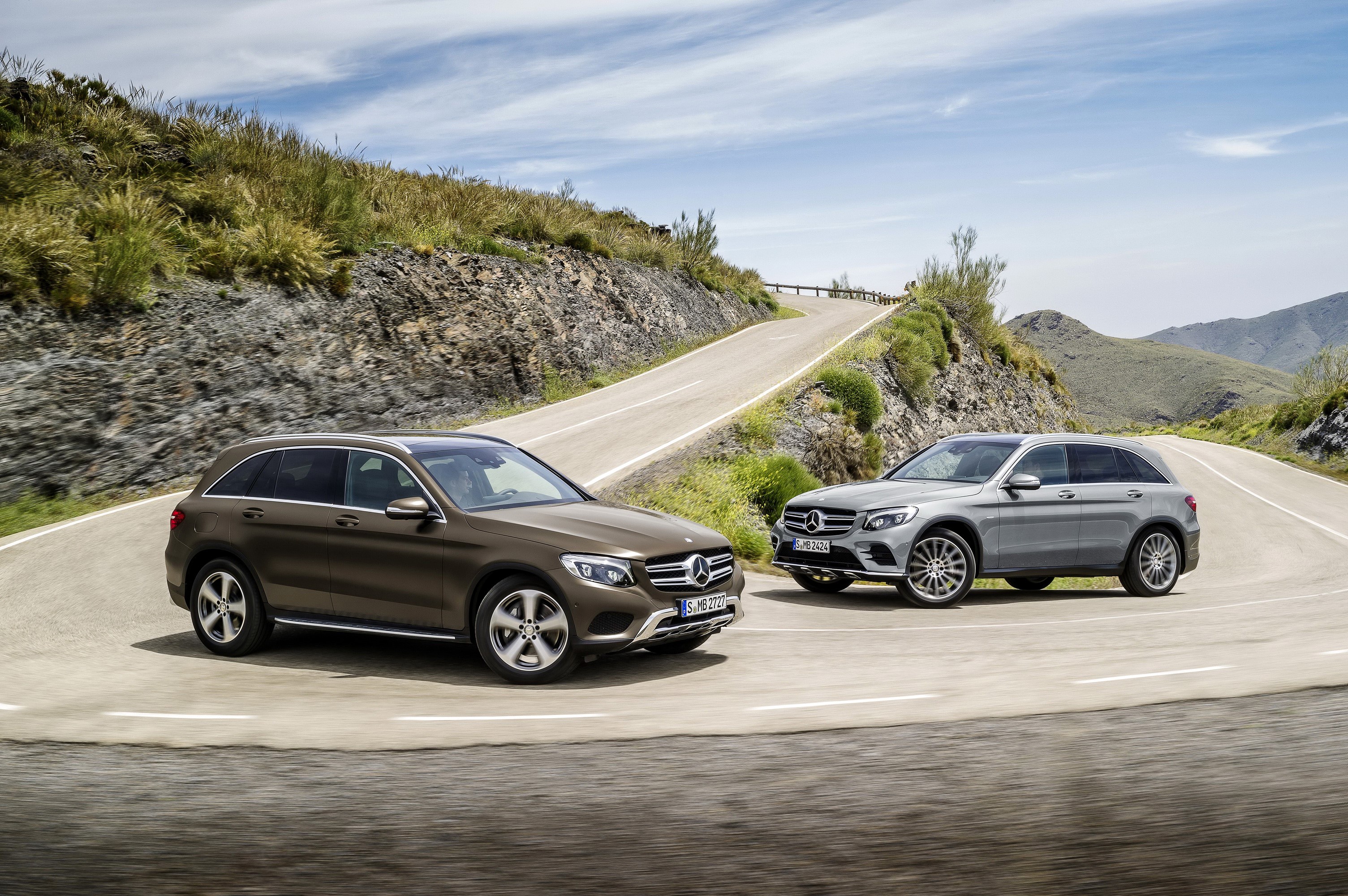 Two Mercedes-Benz GLC SUVs on a winding road HD Wallpaper