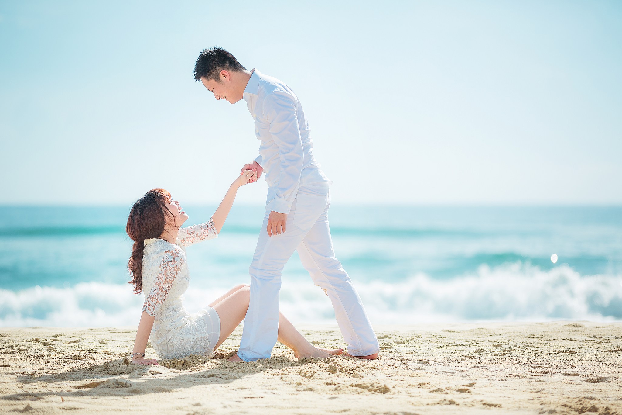 Couple holding hands on a beach HD Wallpaper
