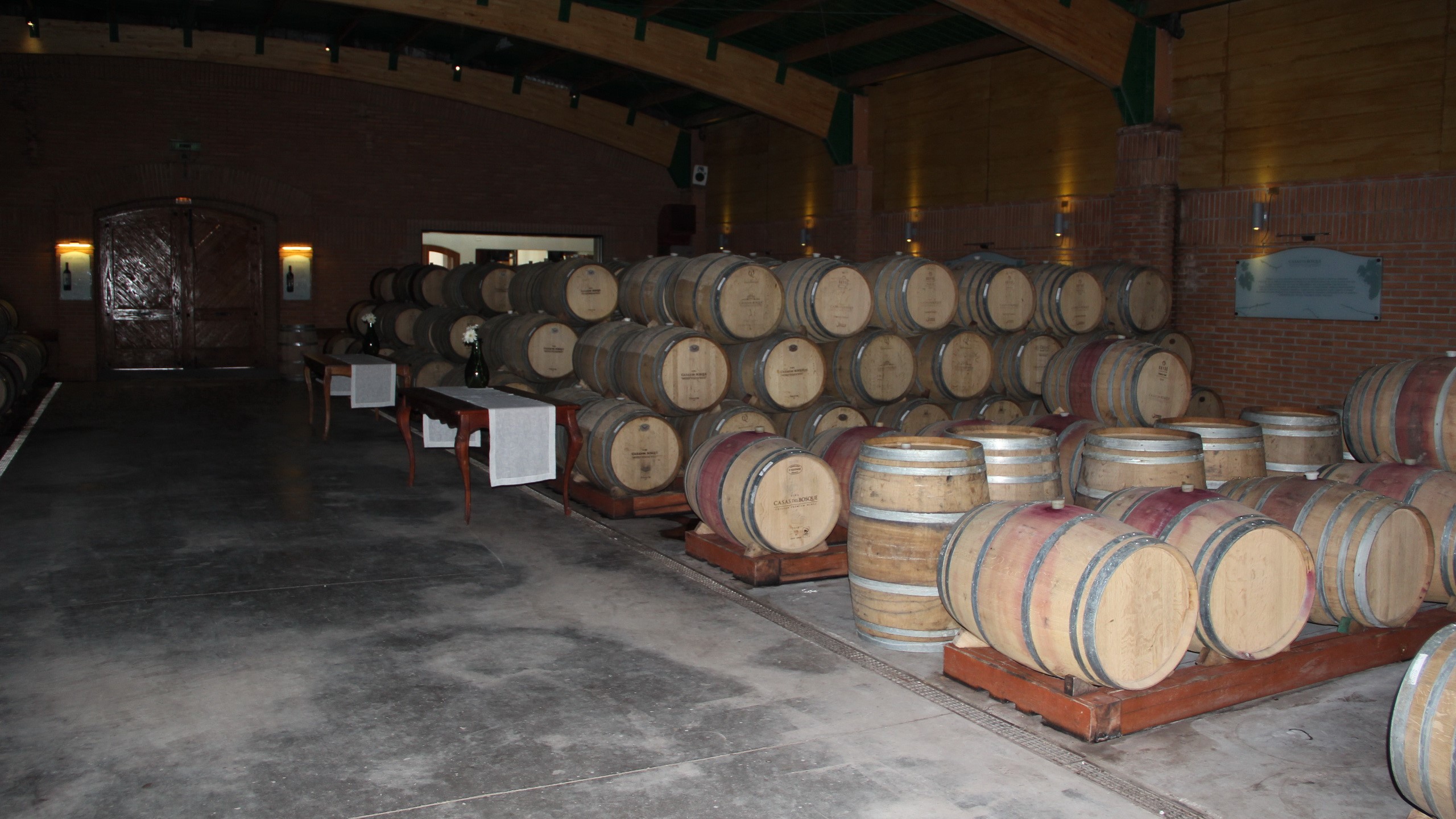 Wine barrels stacked in a Chilean winery cellar HD Wallpaper