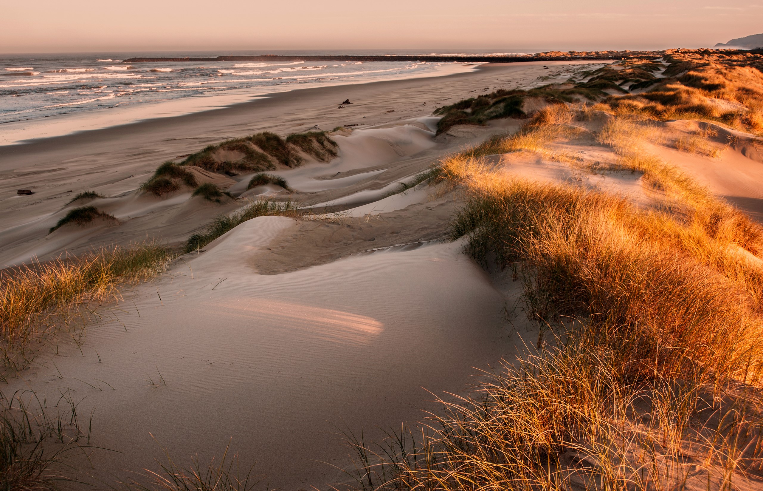 Sand dunes and ocean waves at sunset HD Wallpaper