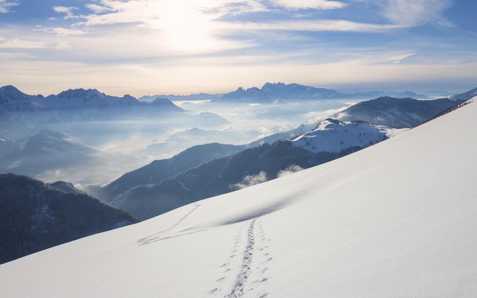 Snowy mountain range with fog in the valleys HD Wallpaper