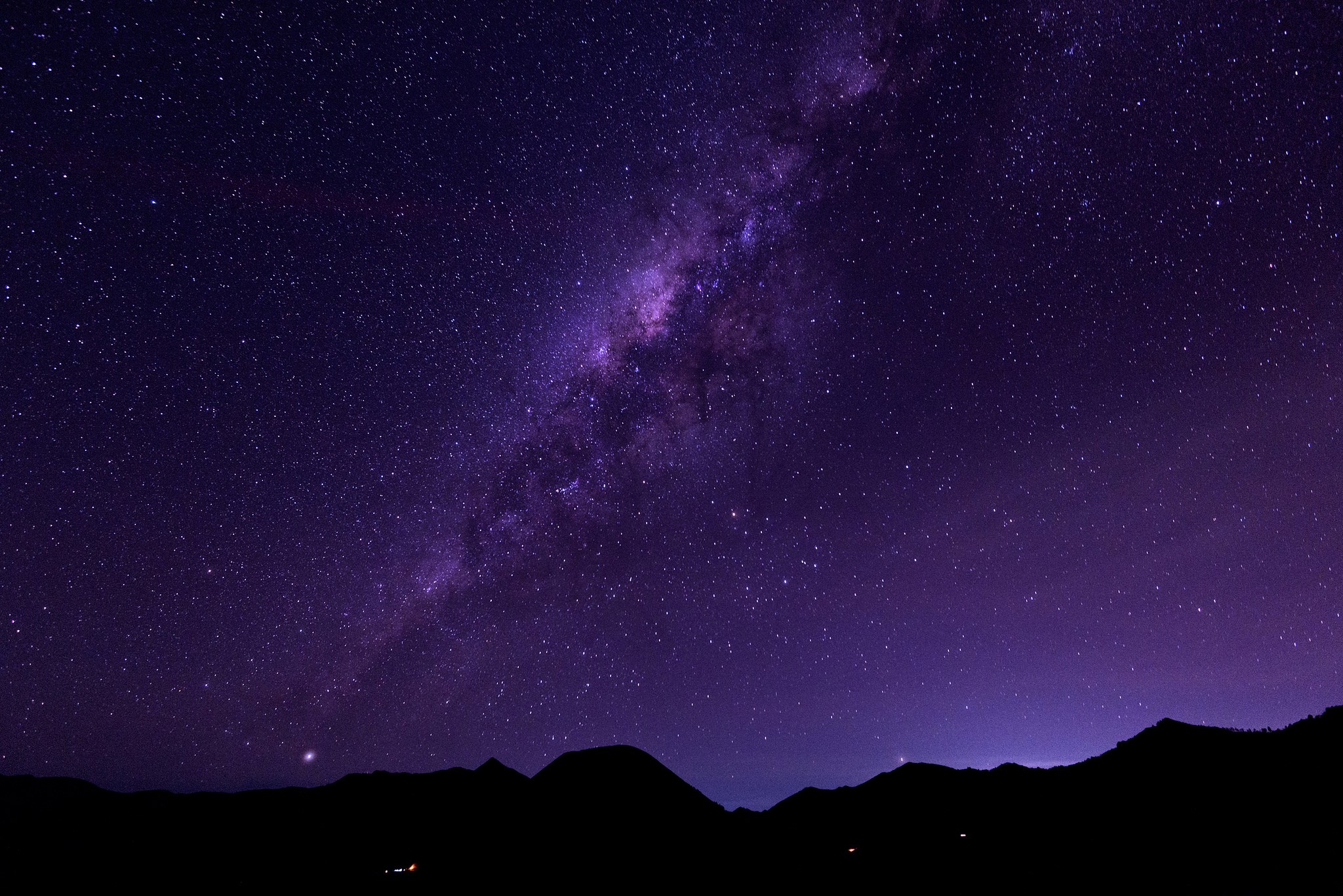 Milky Way galaxy over silhouetted mountains at night HD Wallpaper