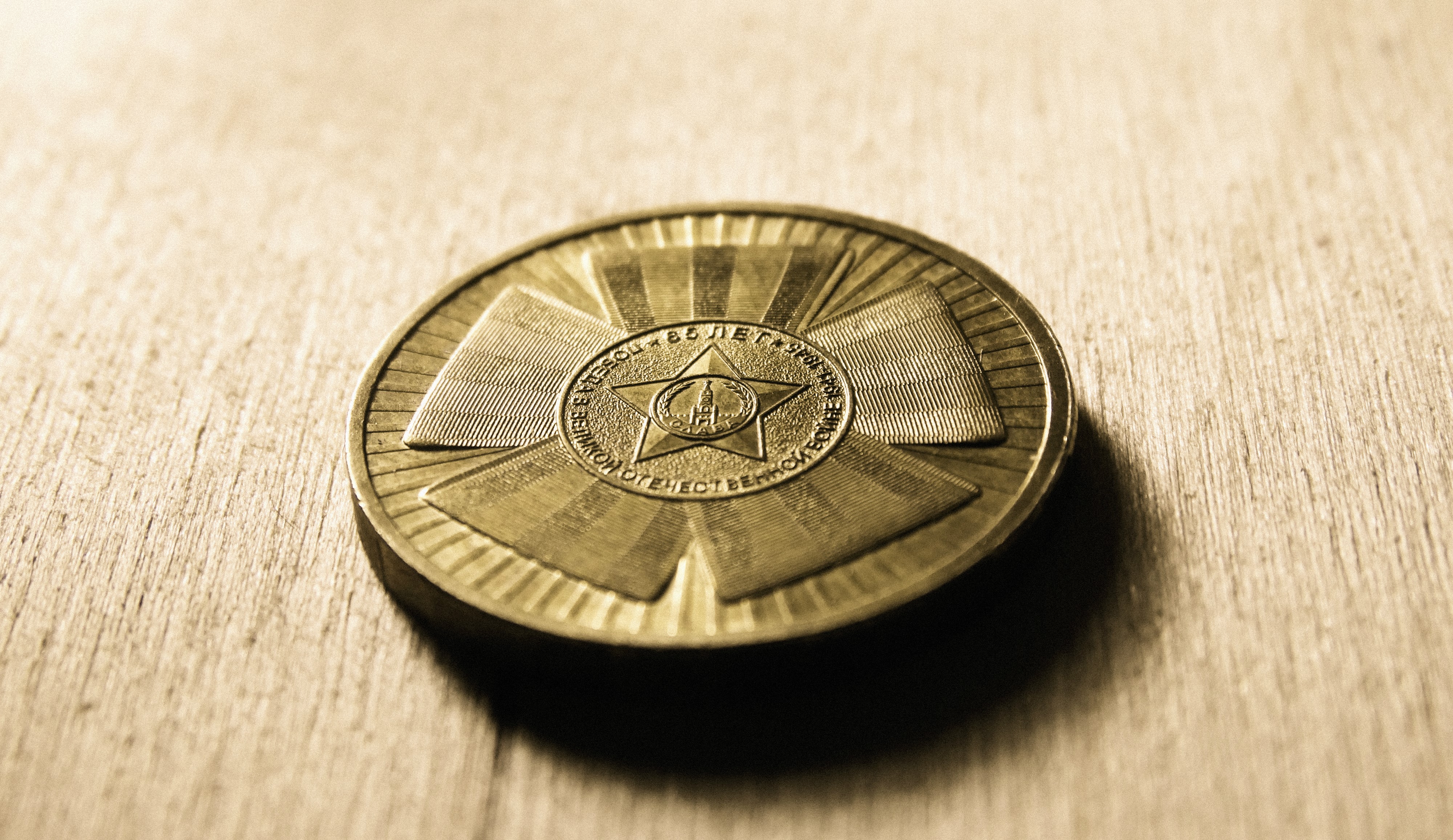 Medal with star and inscription on wooden surface HD Wallpaper