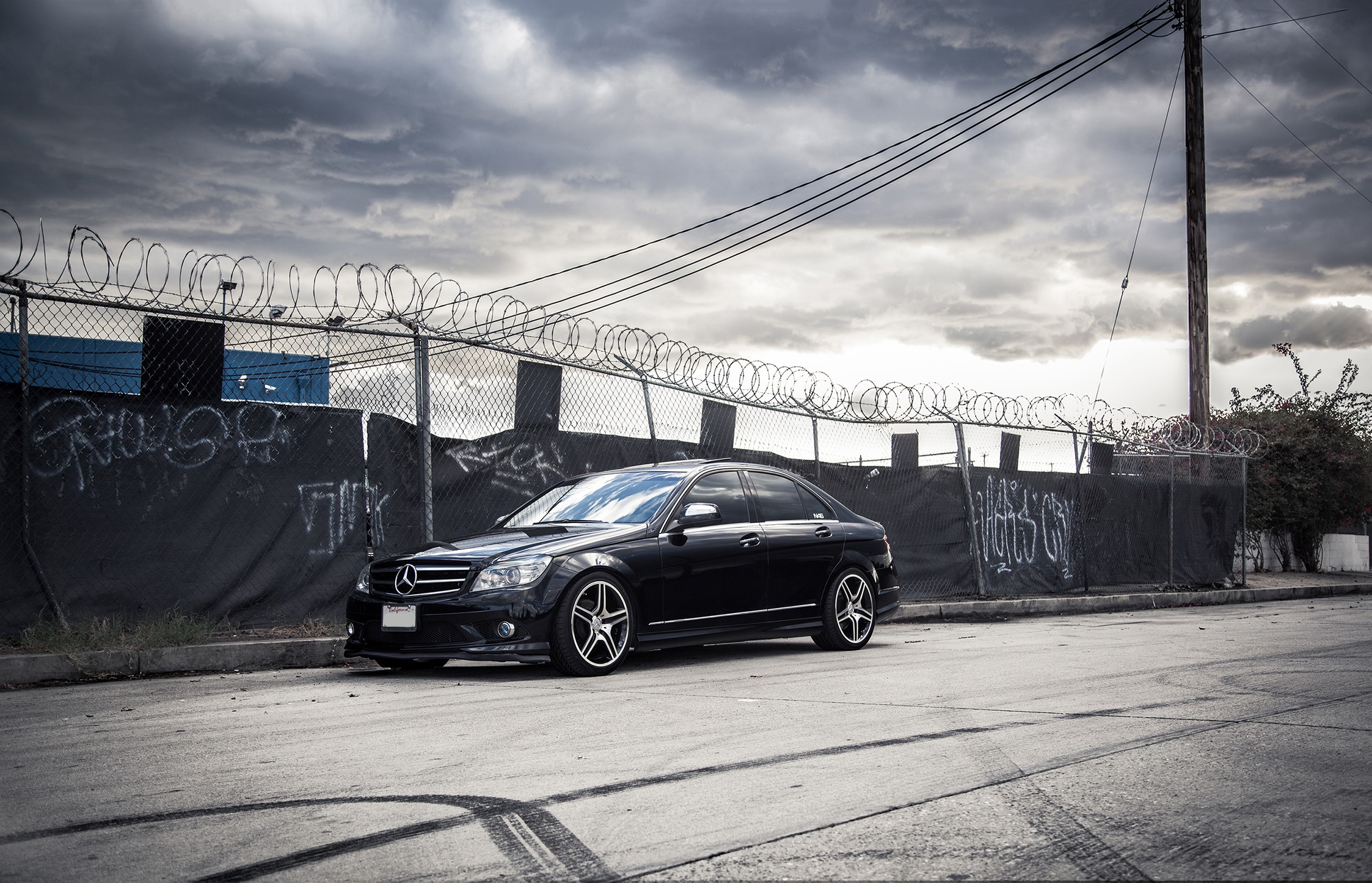 Black Mercedes-Benz C300 with Vossen wheels parked by a fence HD Wallpaper