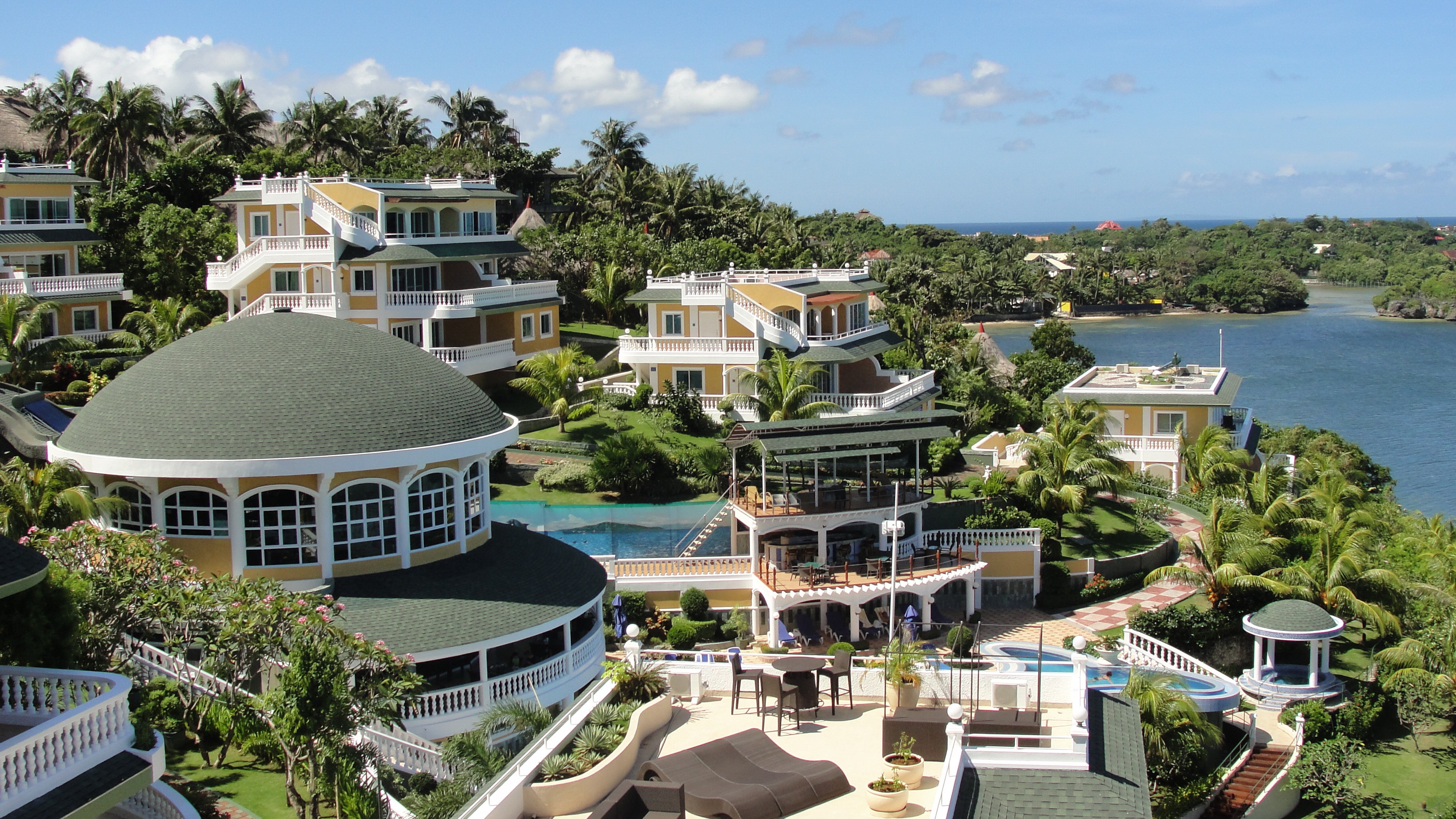 Resort buildings on a tropical island with a bay HD Wallpaper