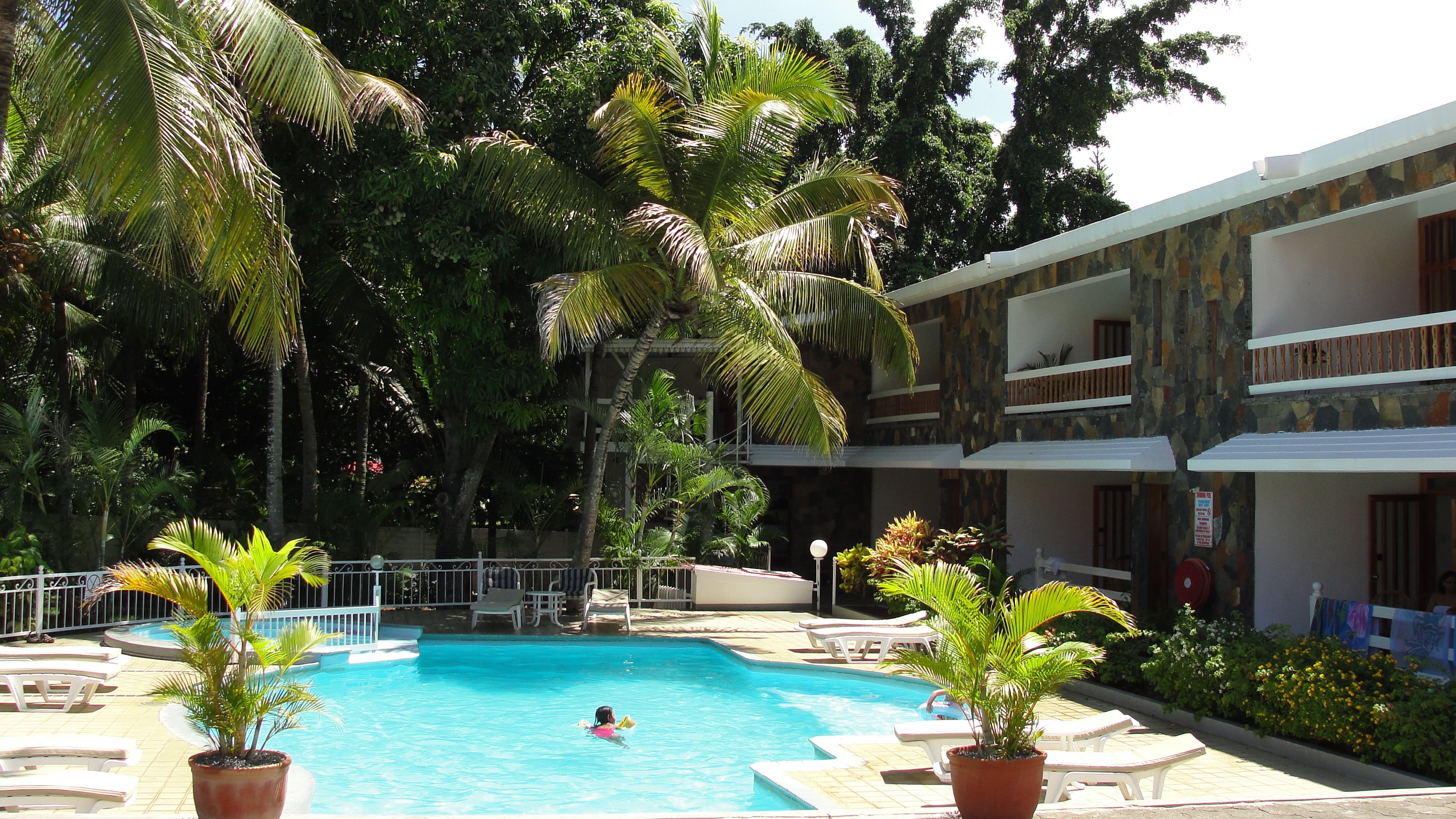 Swimming pool and hotel building with palm trees HD Wallpaper