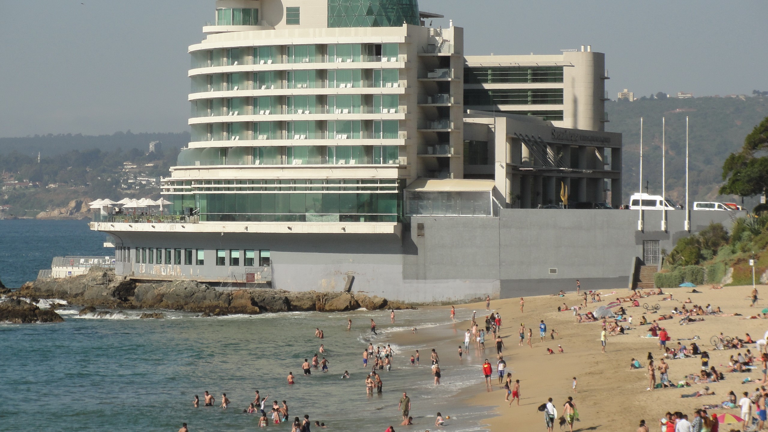 People on a beach in front of a modern hotel in Valparaiso, Chile HD Wallpaper