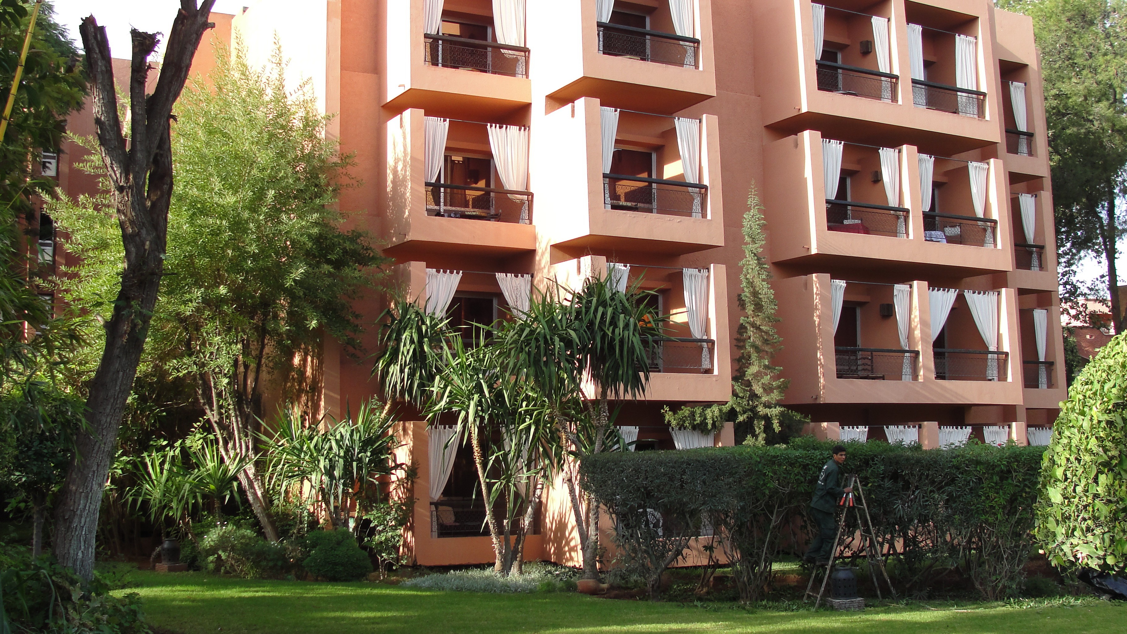 Hotel building with balconies and trees in Marrakech, Morocco HD Wallpaper
