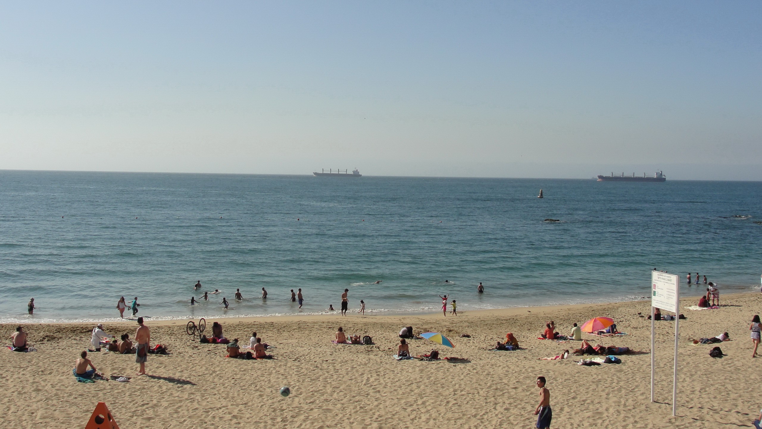People on a sandy beach with ships on the horizon HD Wallpaper