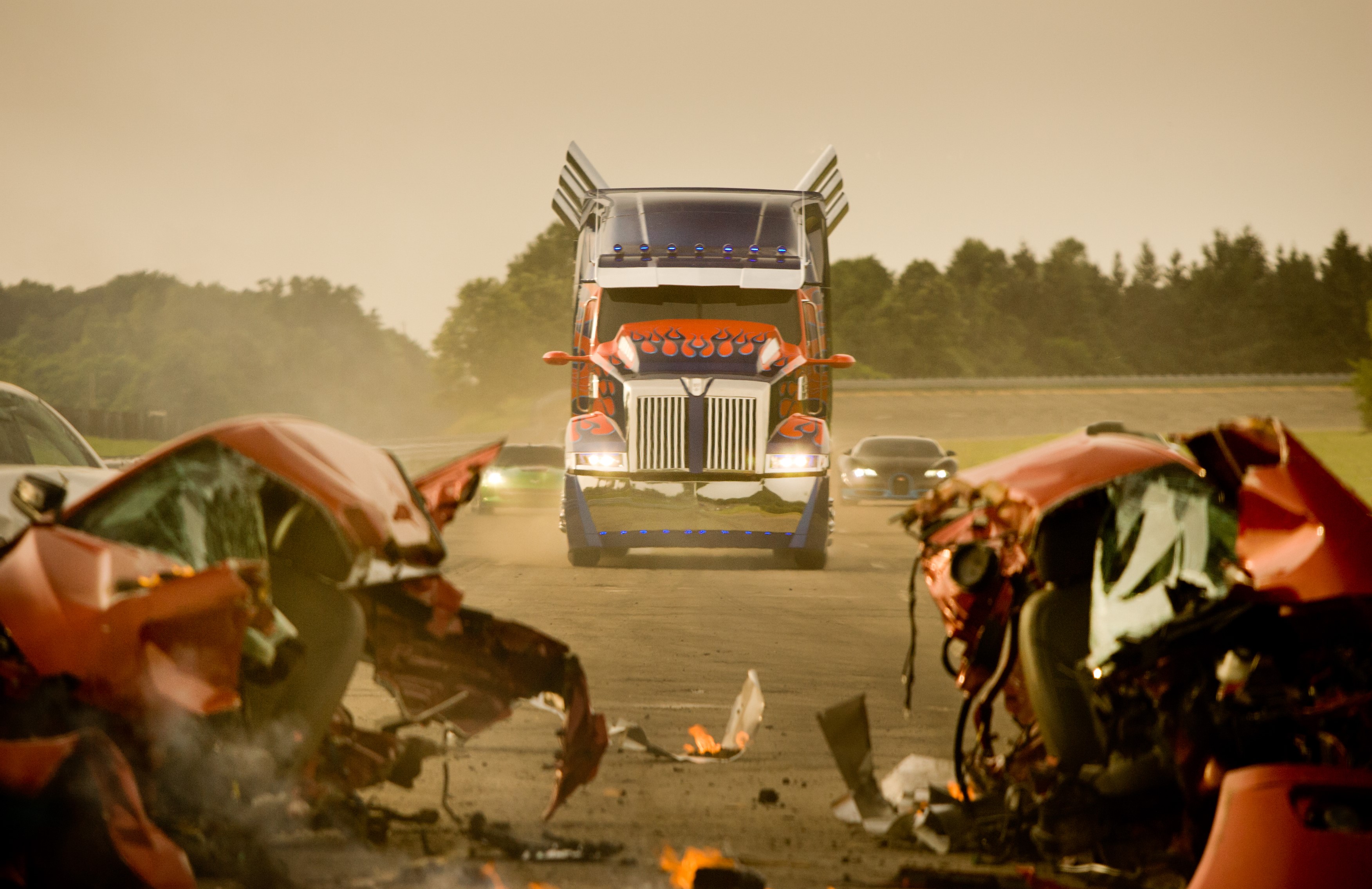 Optimus Prime truck and wrecked cars on a road HD Wallpaper