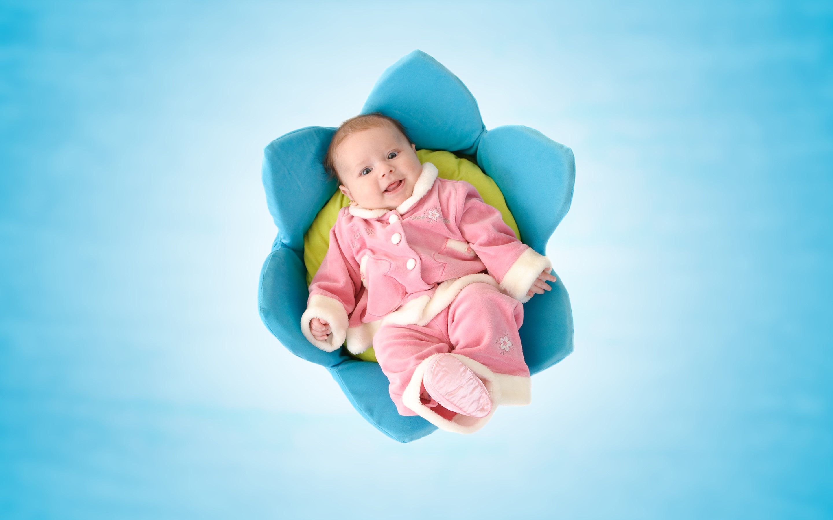 Baby in a flower-shaped cushion HD Wallpaper