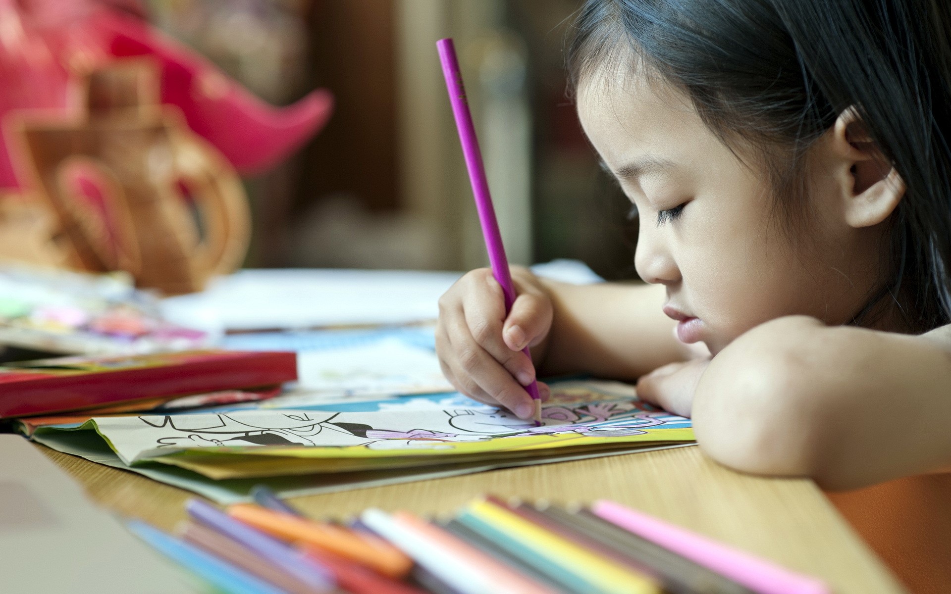 Young girl coloring in a book HD Wallpaper