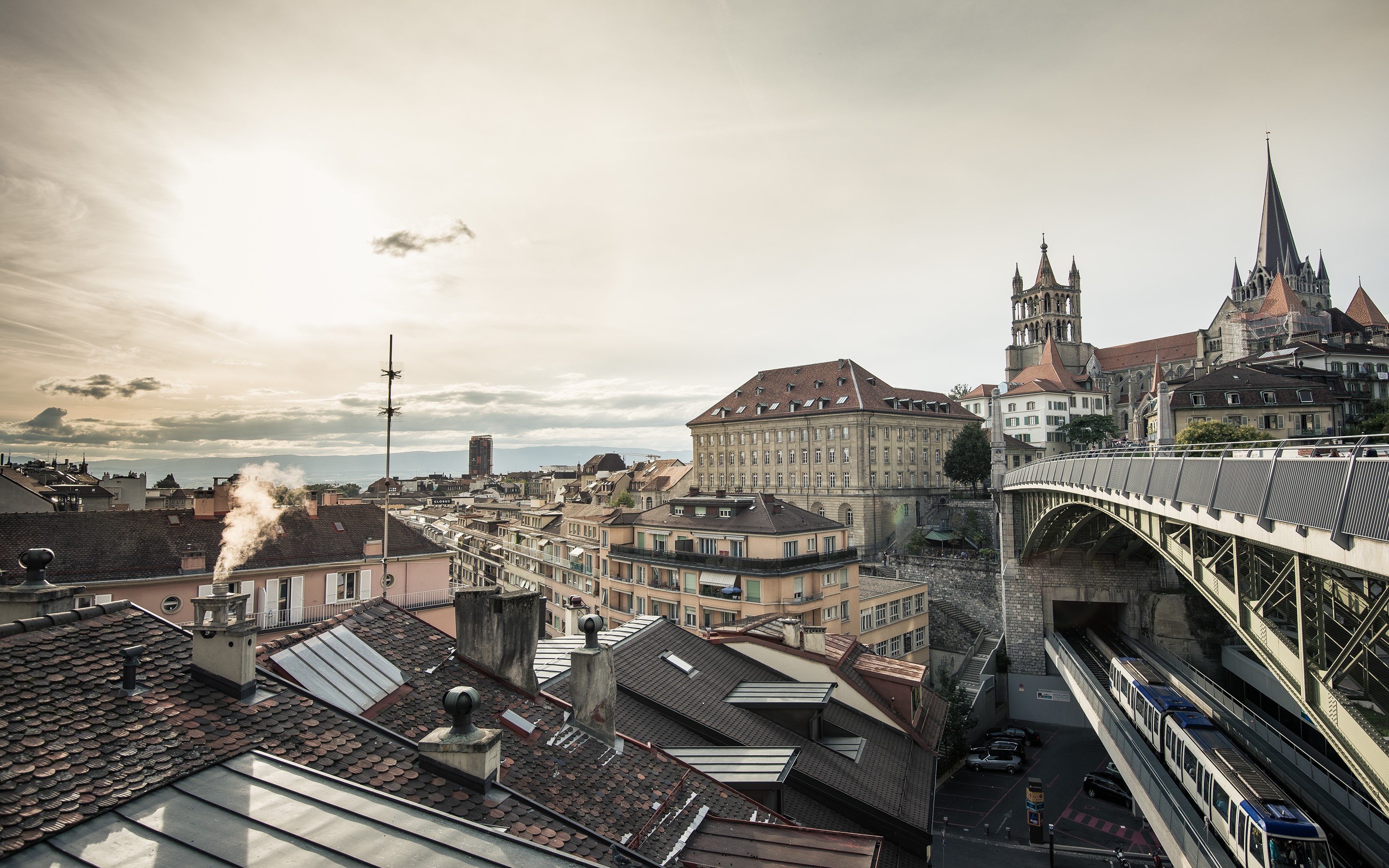 Lausanne Cathedral and train bridge over city HD Wallpaper