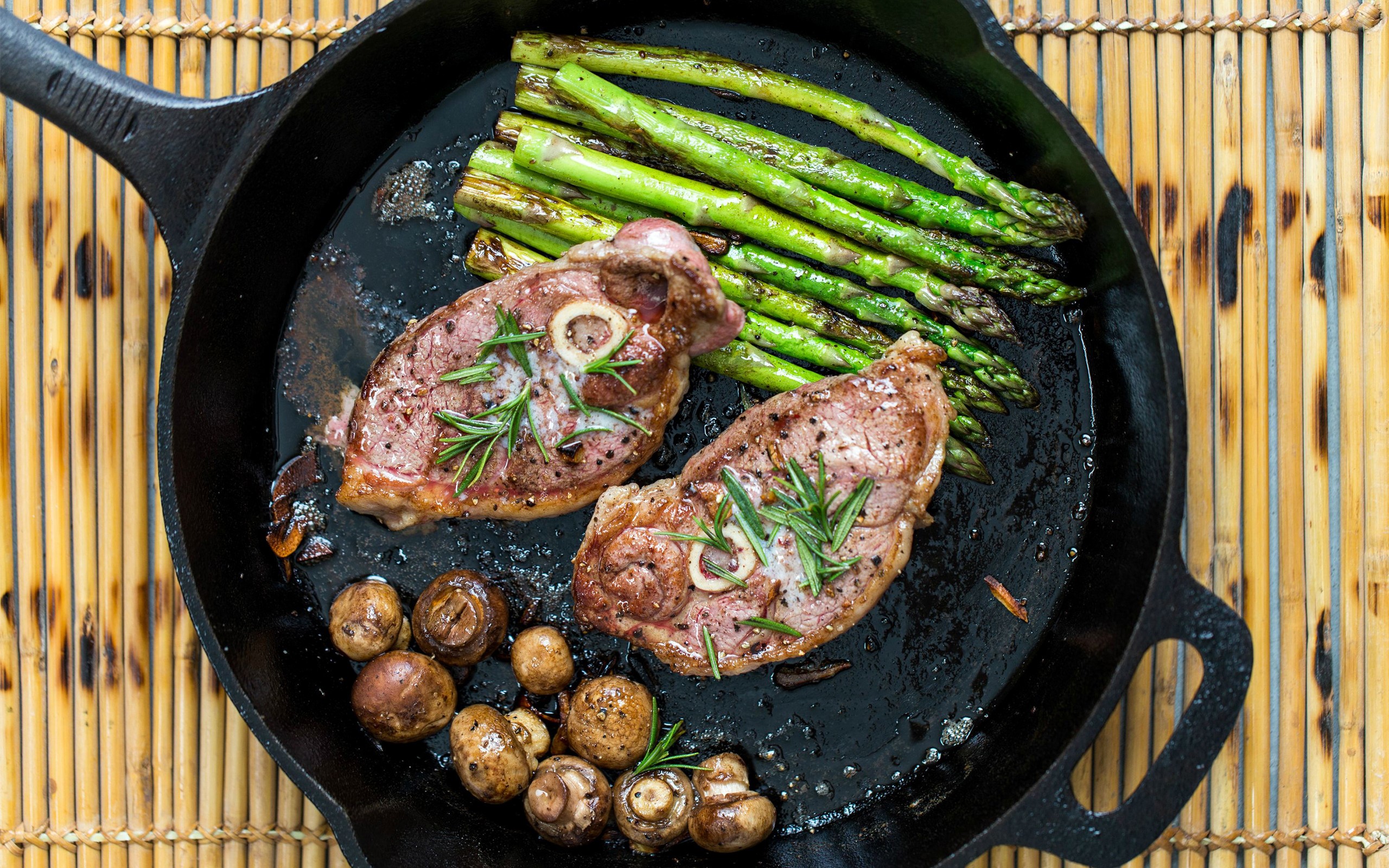 Lamb chops with asparagus and mushrooms in a cast iron skillet HD Wallpaper