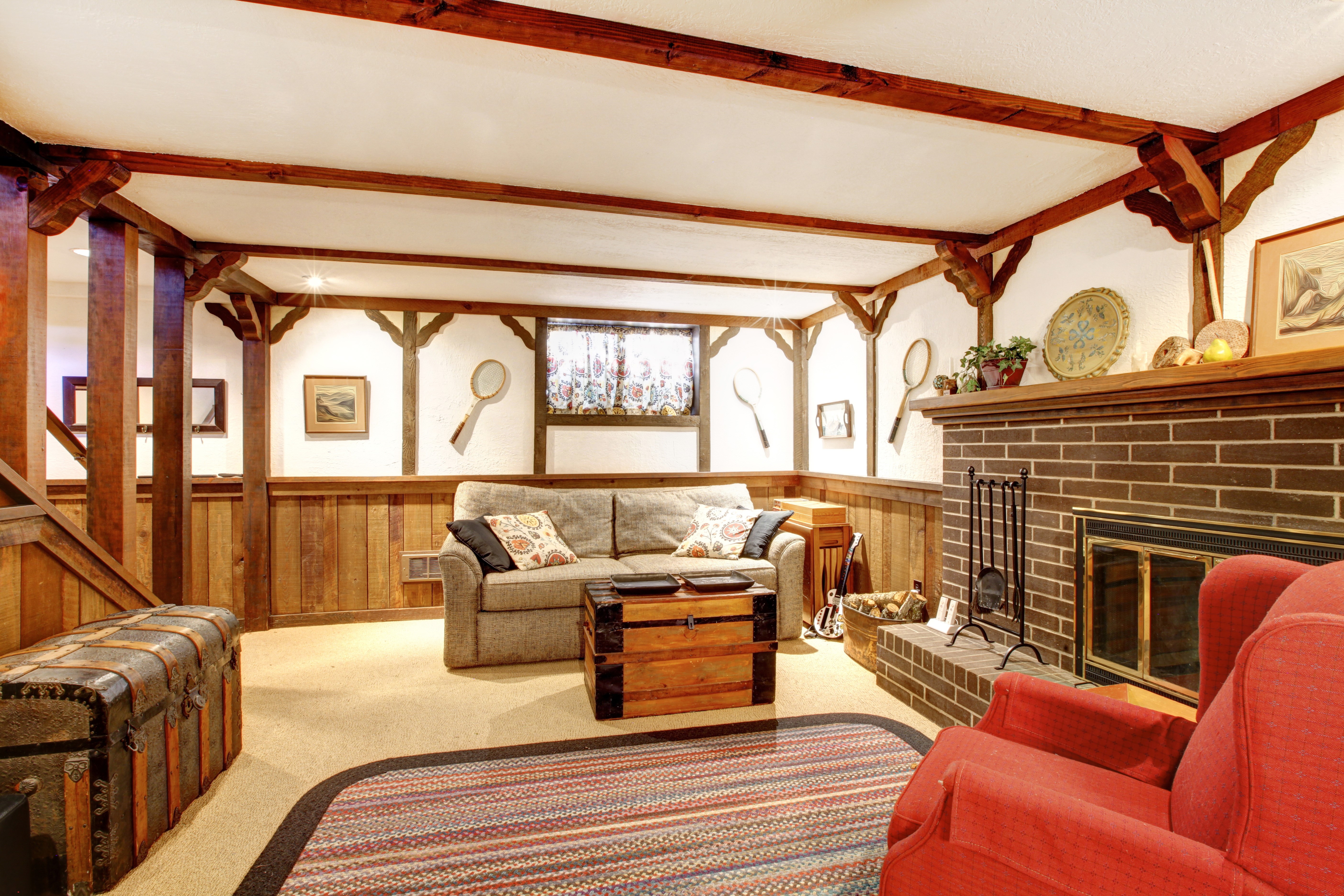 Cozy basement living room with fireplace and sofa HD Wallpaper