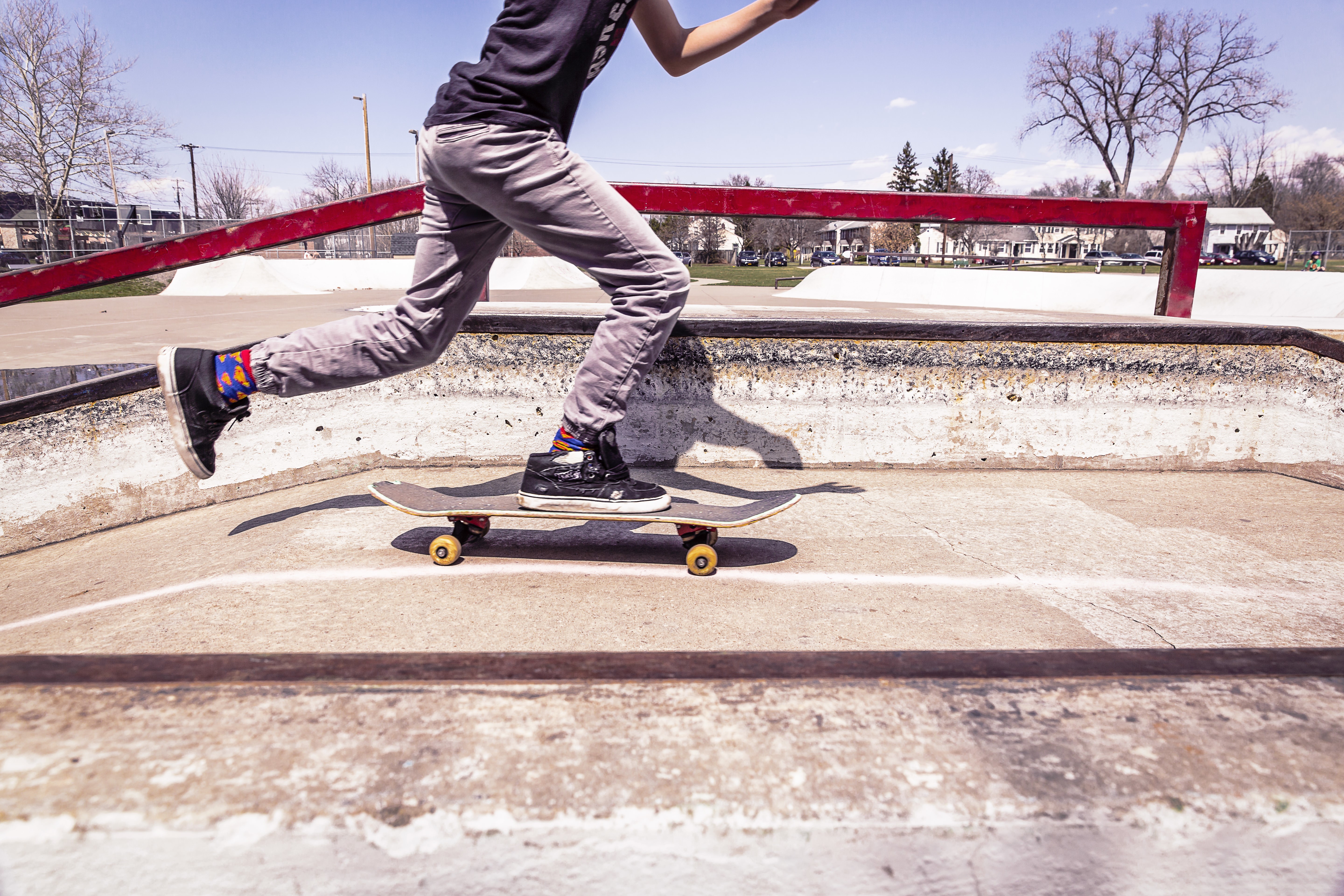 Skateboarder in athletic shoes at a skatepark HD Wallpaper