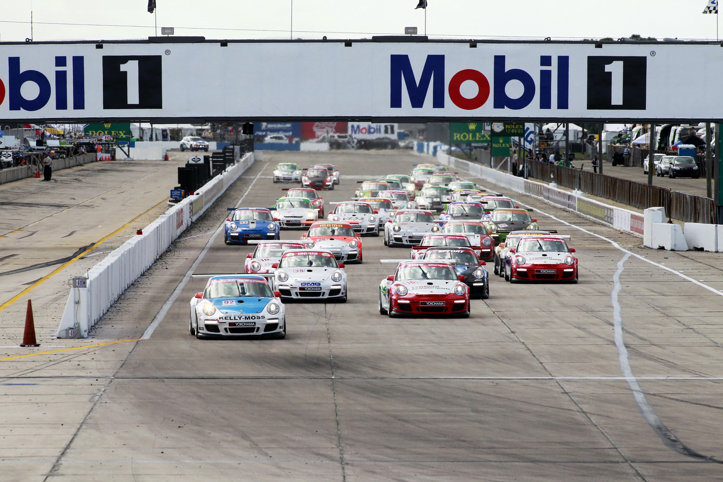 Porsche Race Cars Lined Up Under Mobil 1 Sign HD Wallpaper
