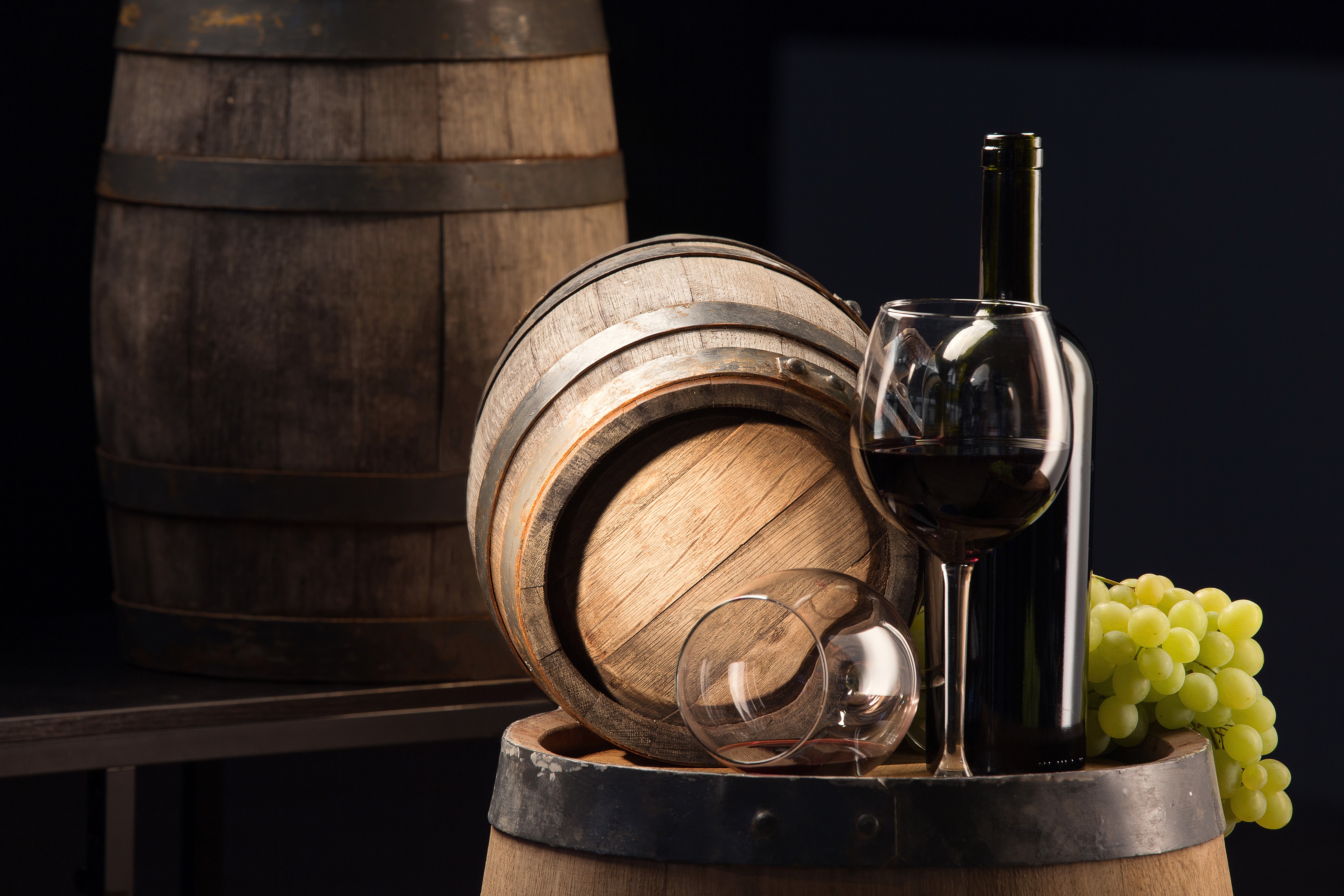 Wine bottle, glass, grapes, and barrels HD Wallpaper