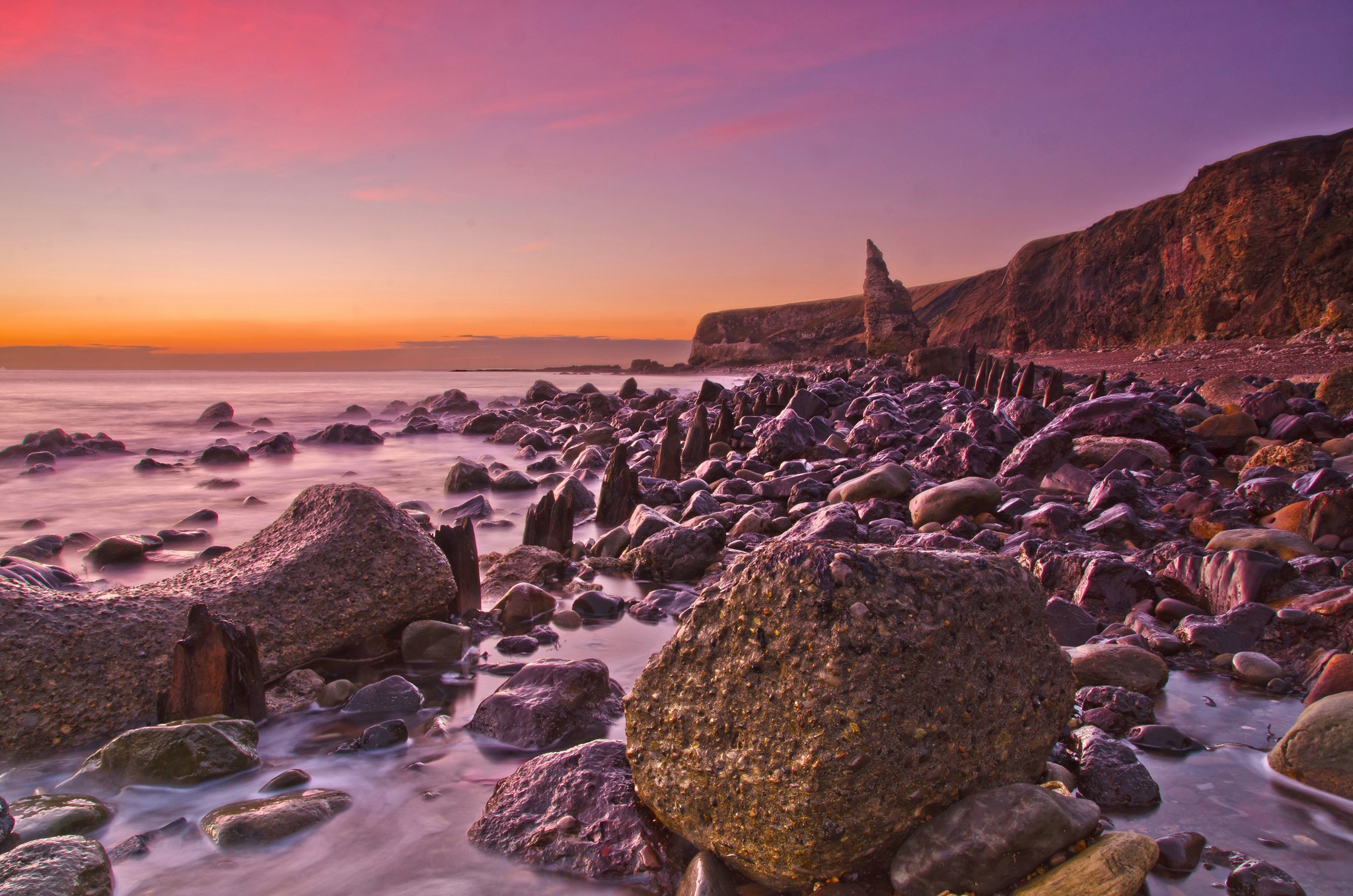 Rocky coast with sea and colorful sunset sky HD Wallpaper