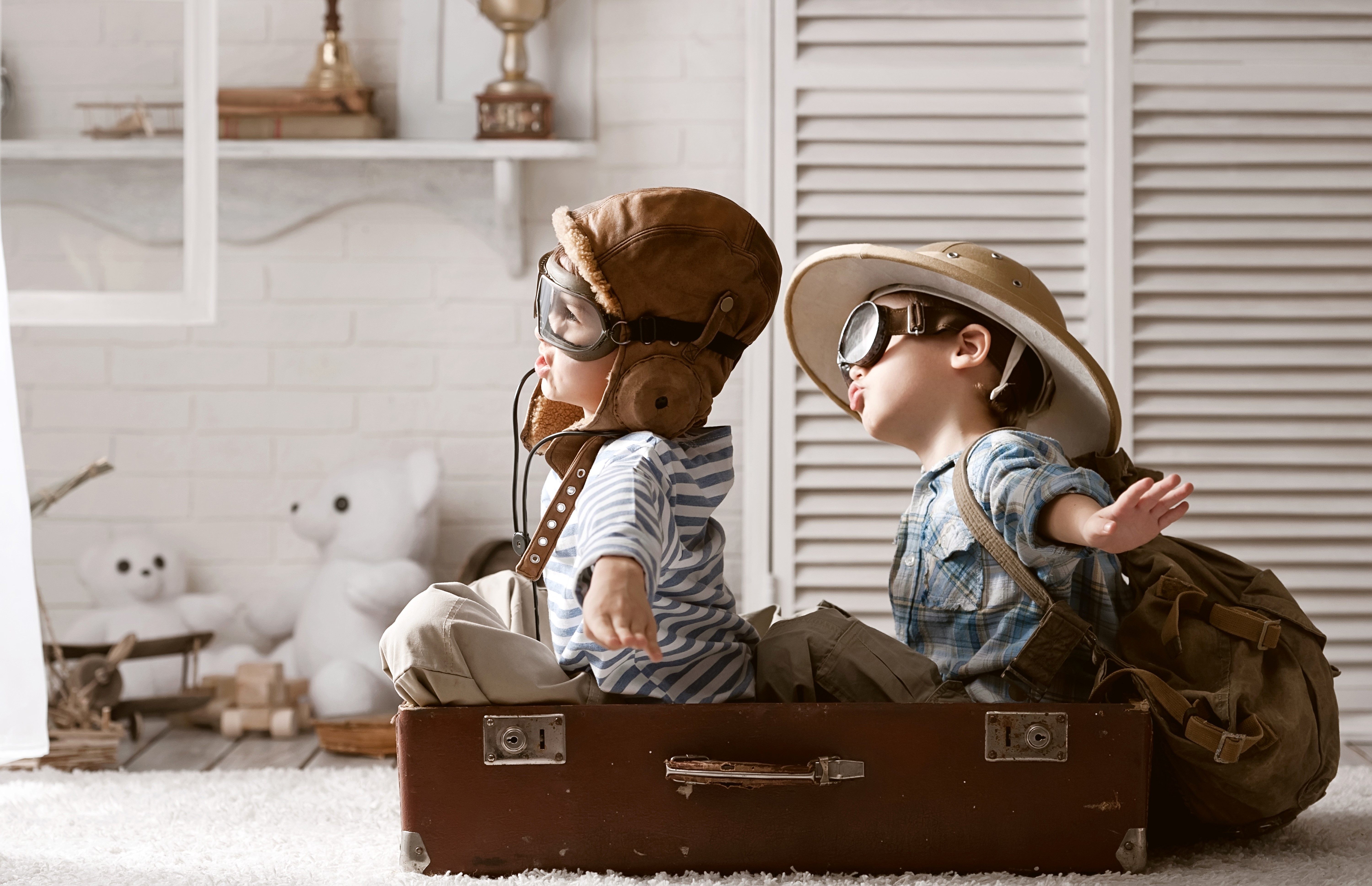 Two boys dressed as pilots and explorers in a suitcase HD Wallpaper