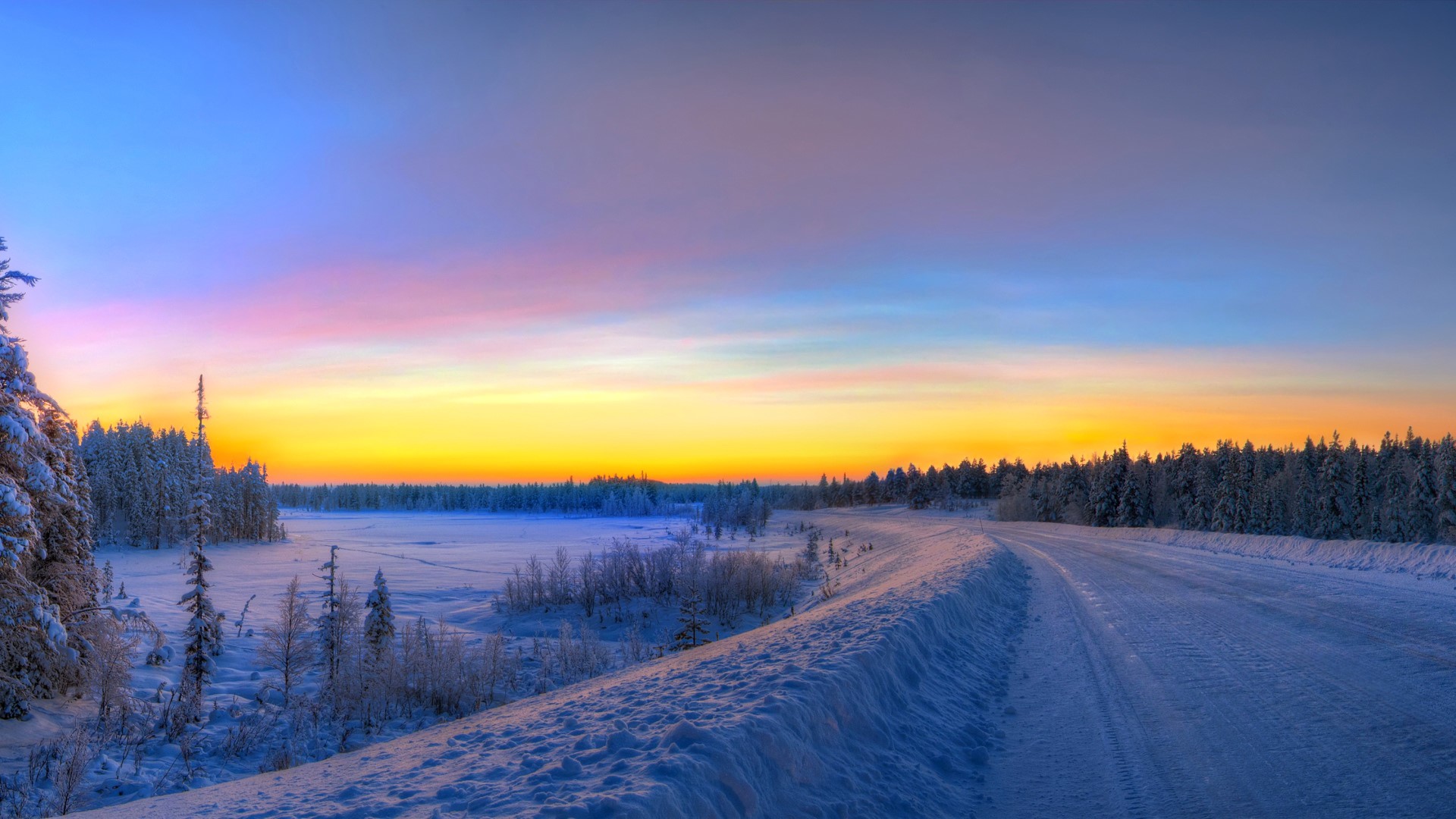 Winter road at sunset with snow-covered trees HD Wallpaper