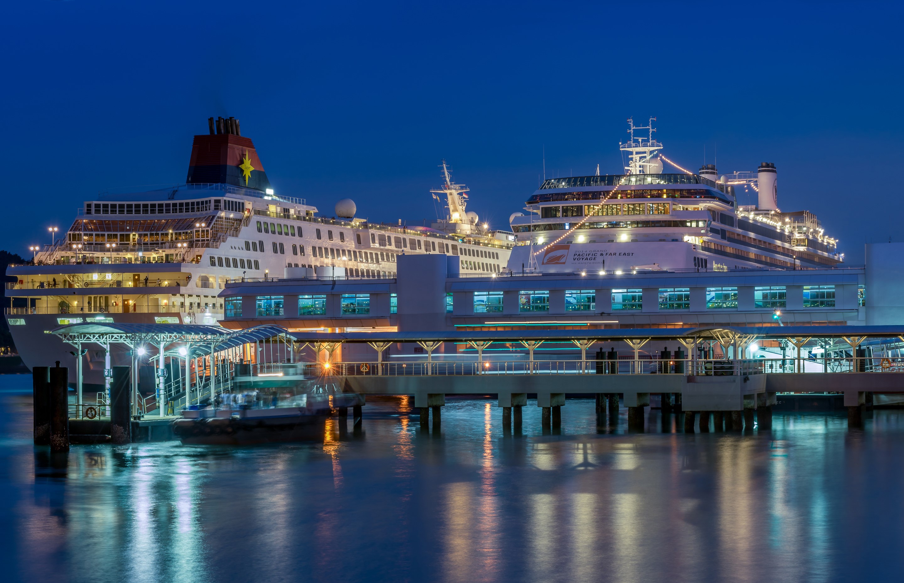 Cruise liners docked at a pier in Singapore at night HD Wallpaper