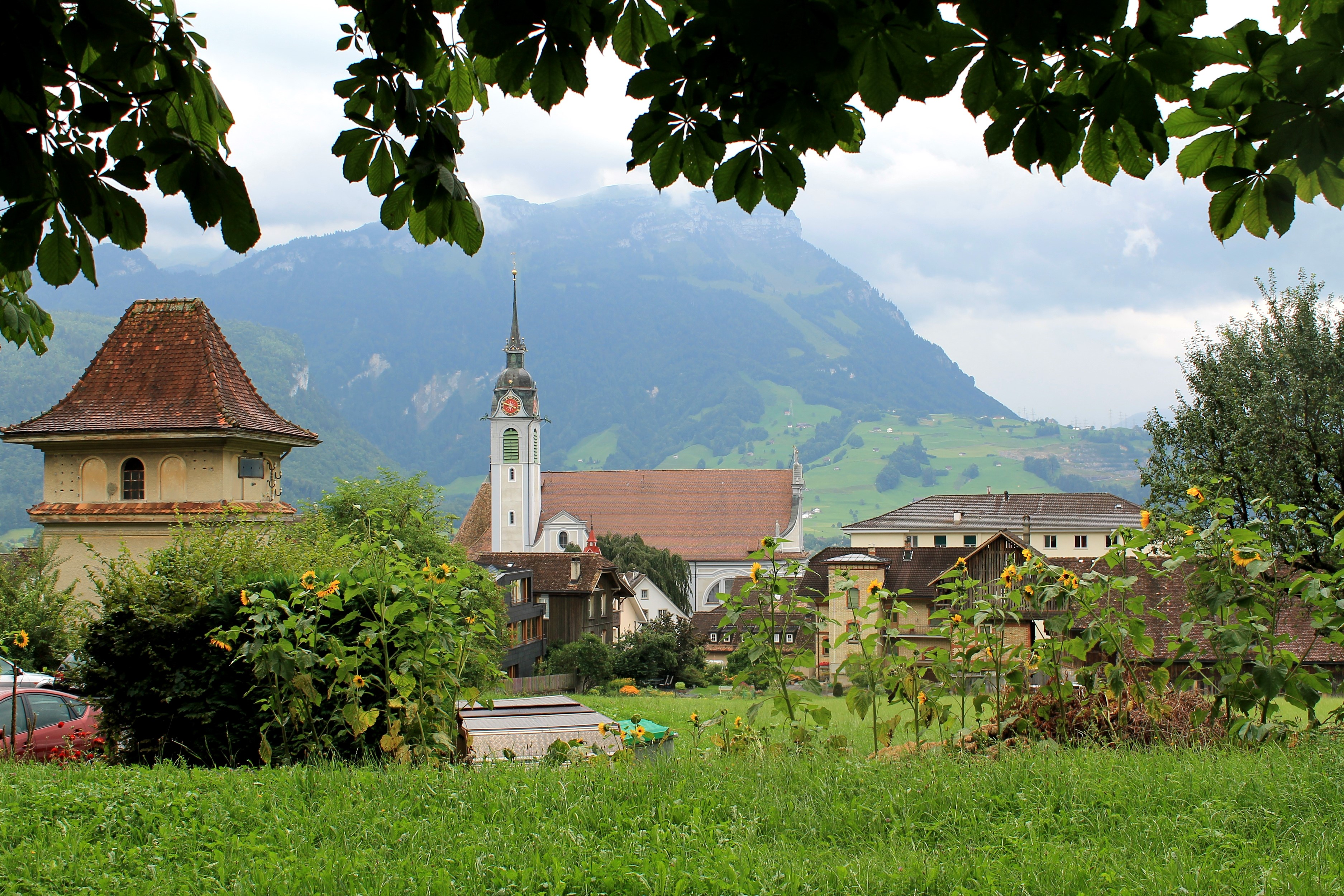 Village with church and mountains in Schwyz, Switzerland HD Wallpaper