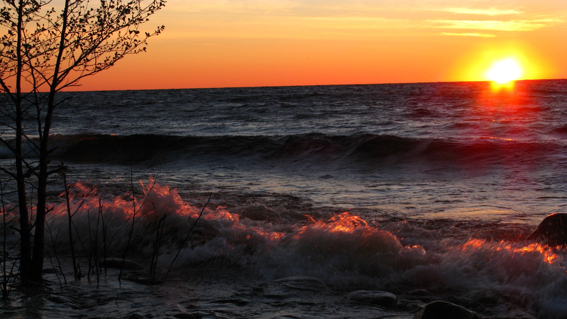 Sunset over the sea with waves crashing HD Wallpaper