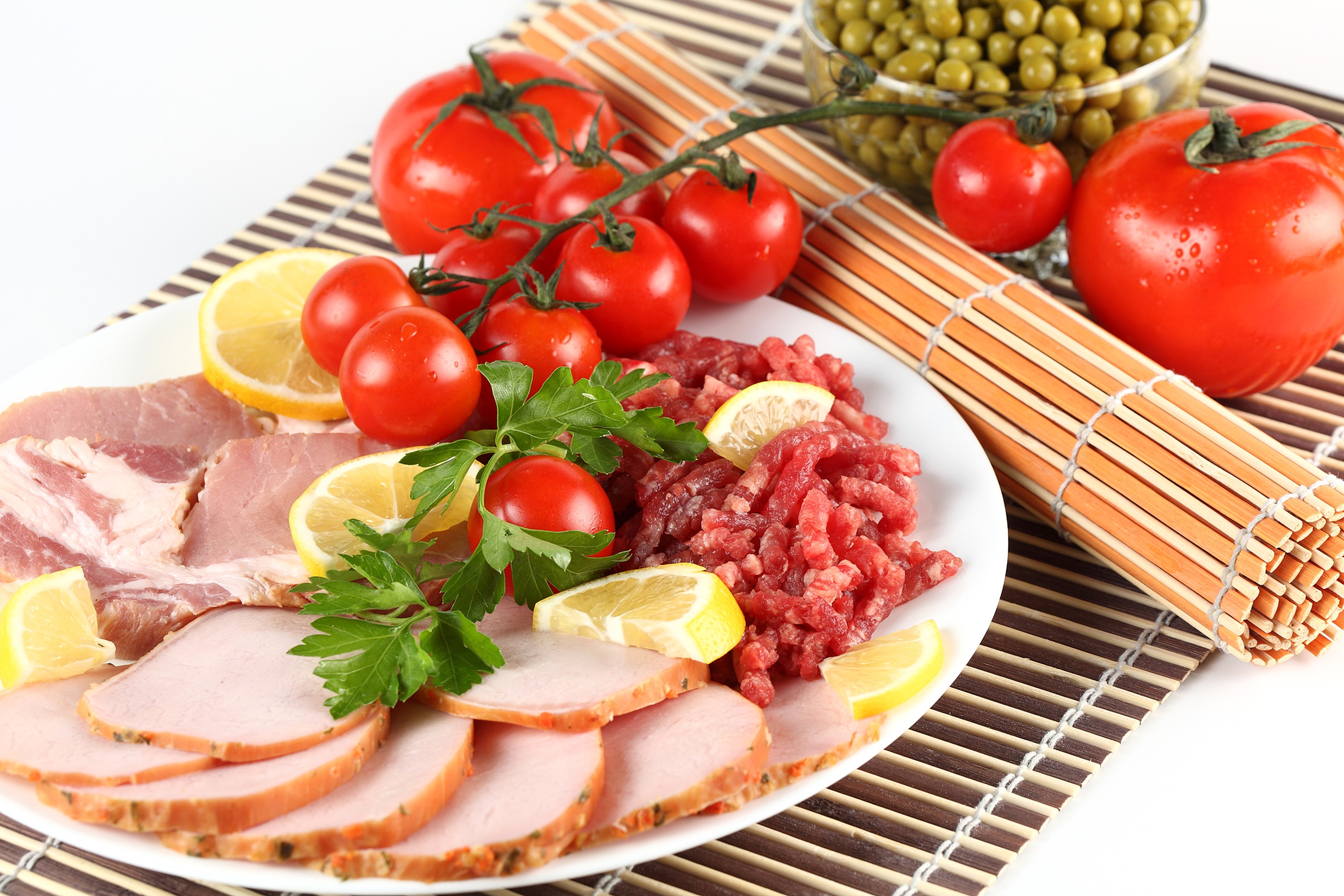 Plate of sliced ham, raw ground meat, tomatoes, lemons, and peas HD Wallpaper