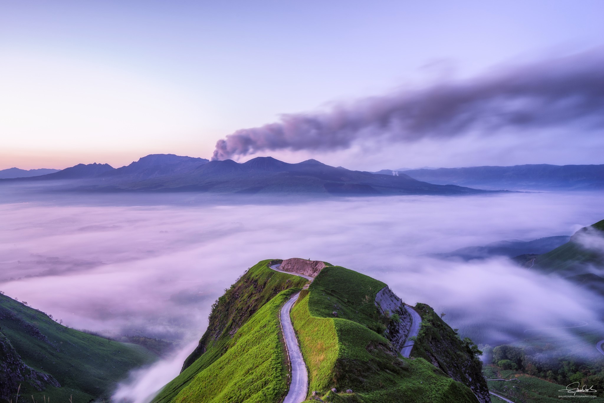 Volcanic smoke over mountains above a sea of clouds HD Wallpaper