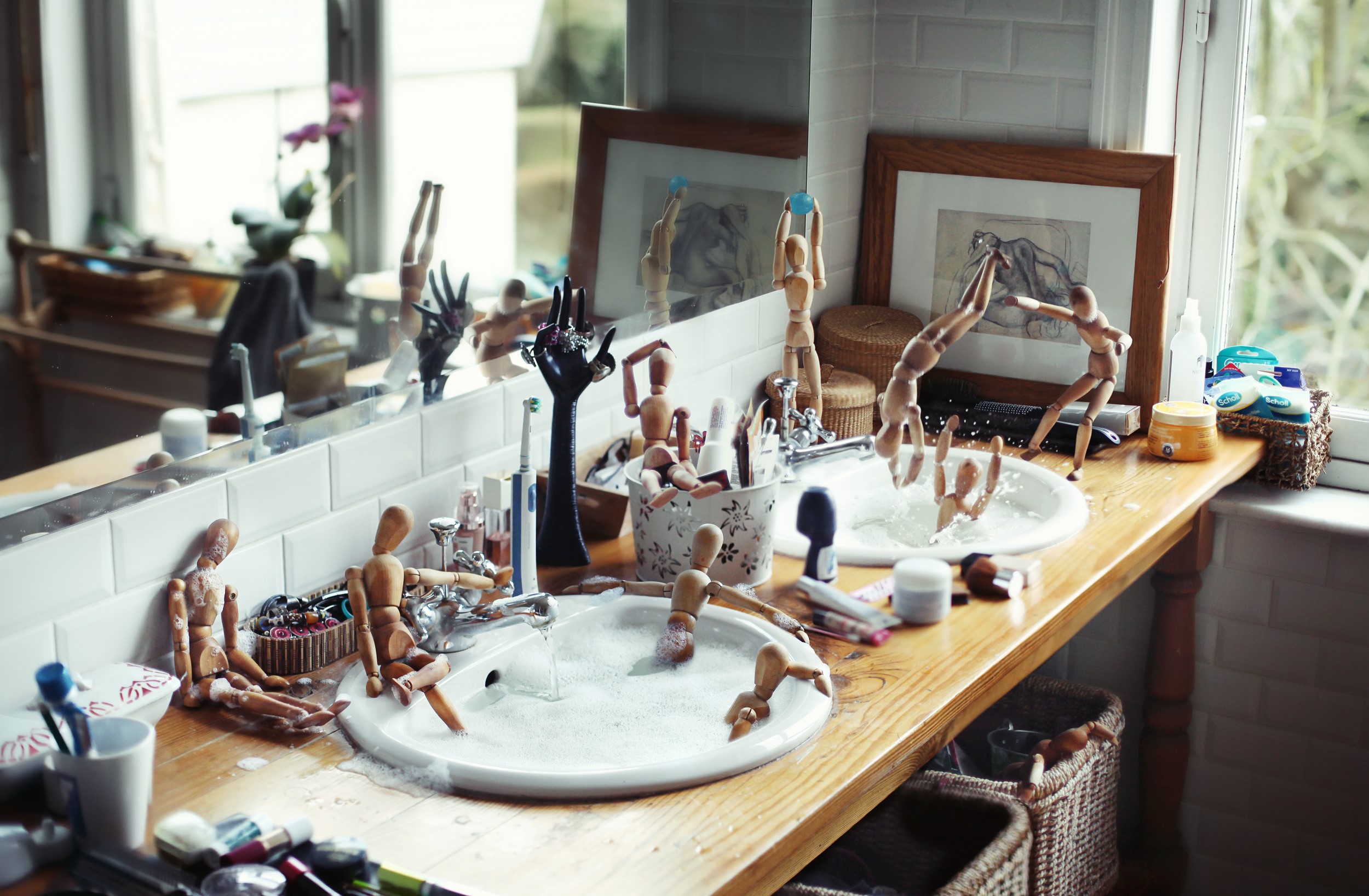 Wooden mannequins playing in a bathroom sink HD Wallpaper