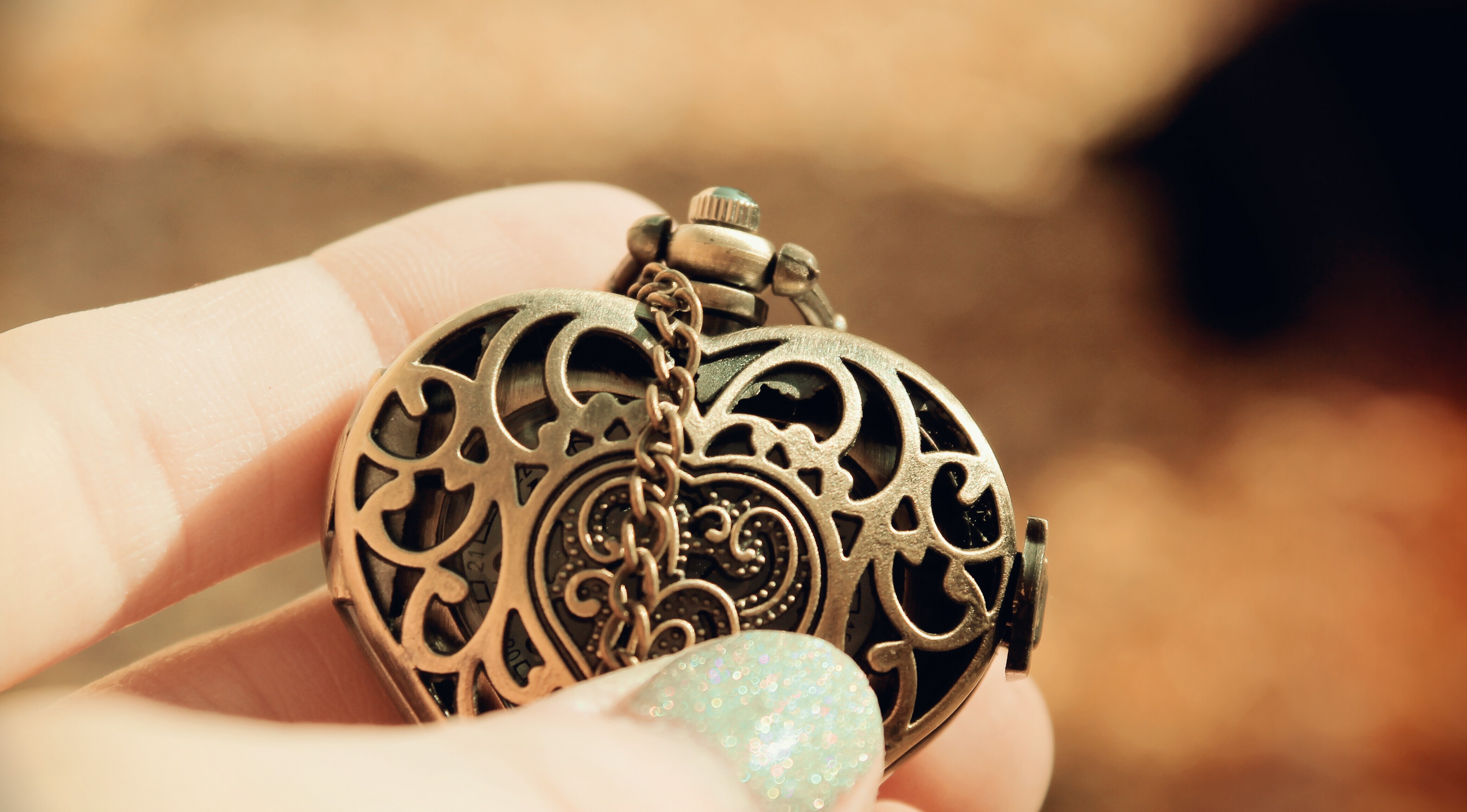 Heart-shaped locket jewelry held by a hand HD Wallpaper
