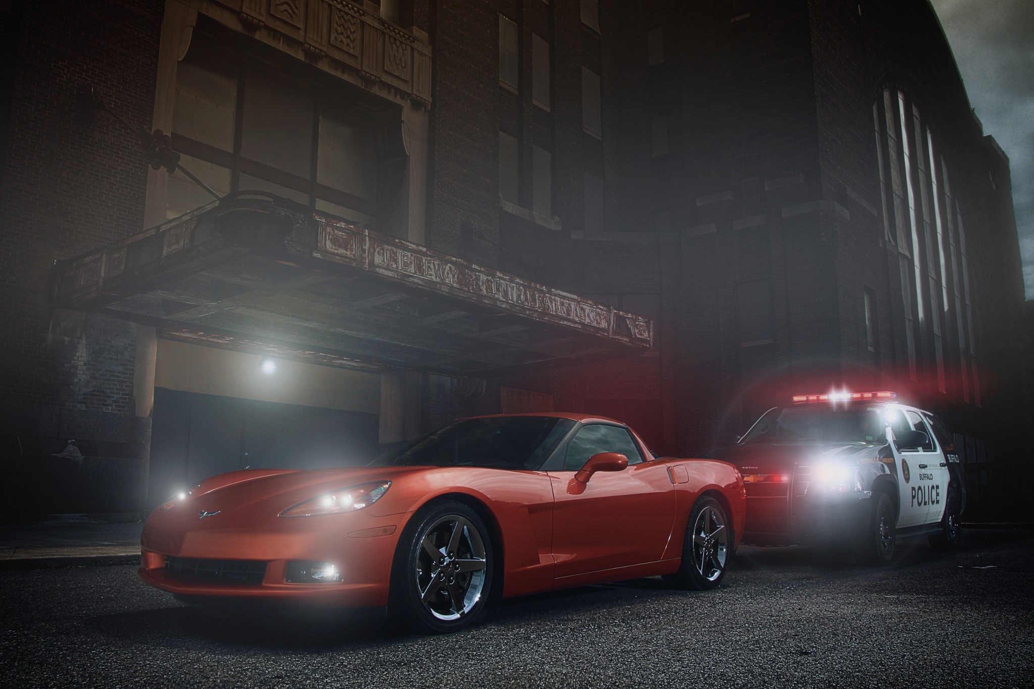 Orange Chevrolet Corvette and Police Car at Night HD Wallpaper