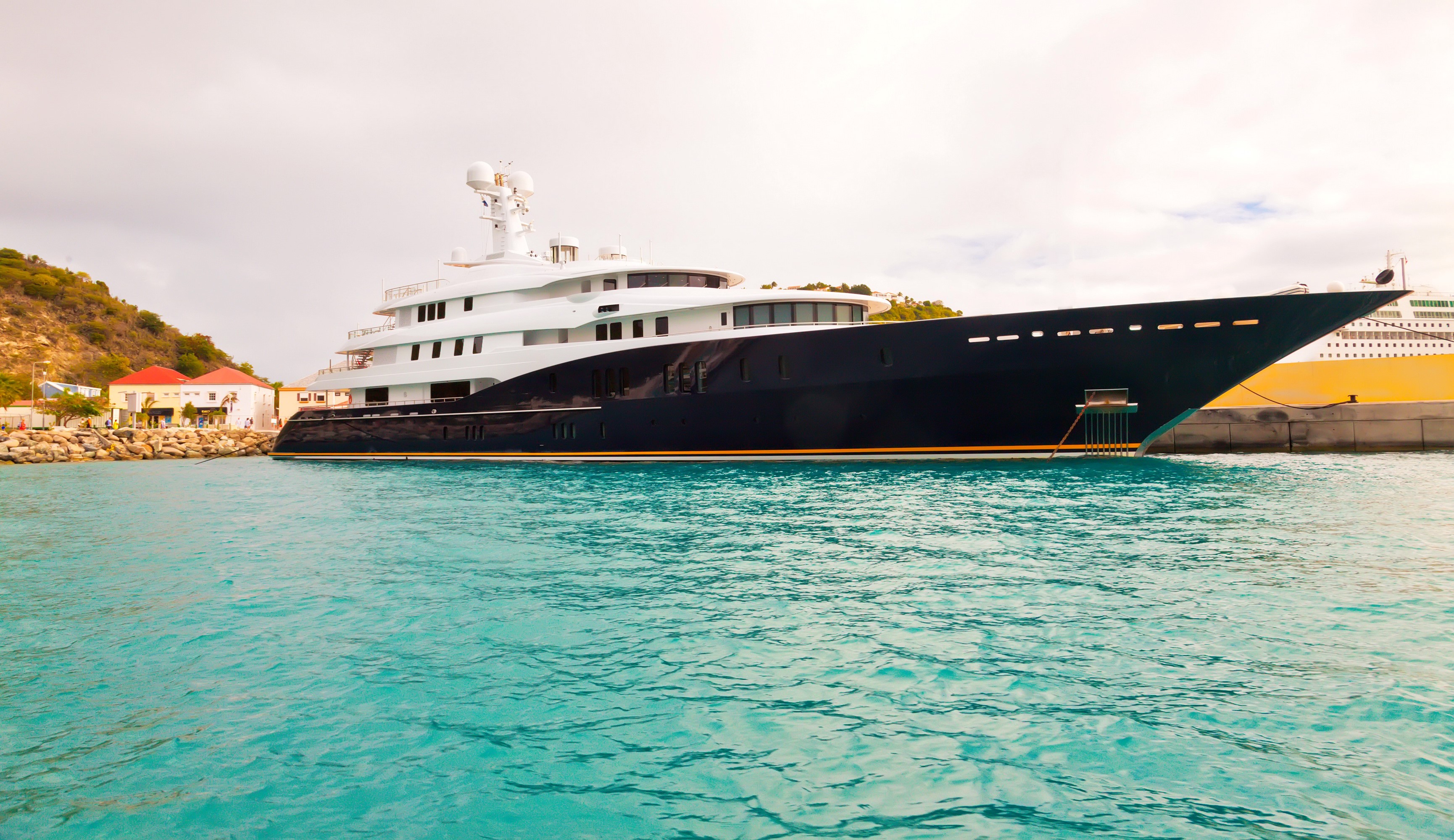 Luxury yacht docked in a harbor with turquoise water HD Wallpaper