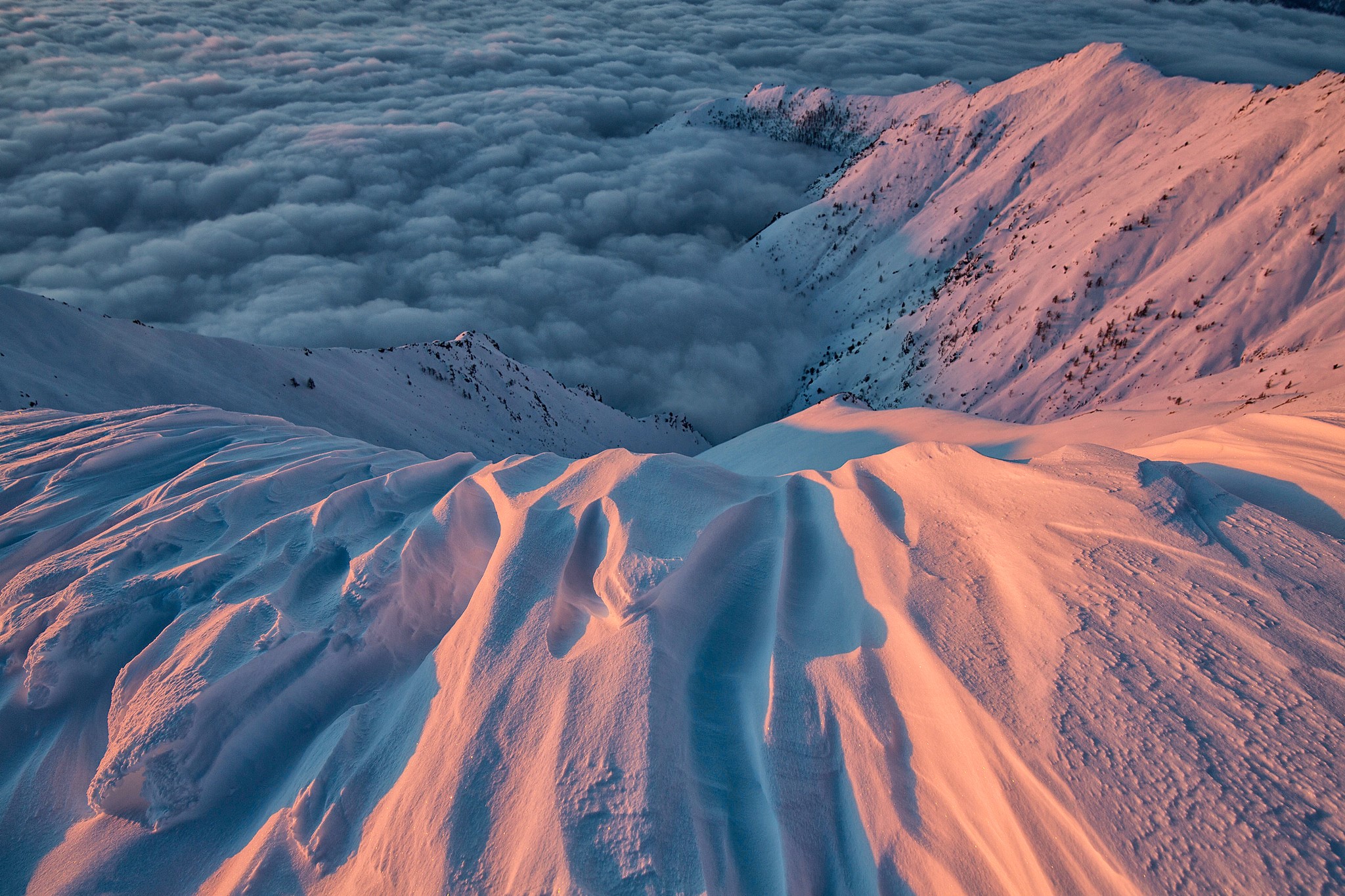 Snowy mountains above clouds at sunrise in the Alps HD Wallpaper