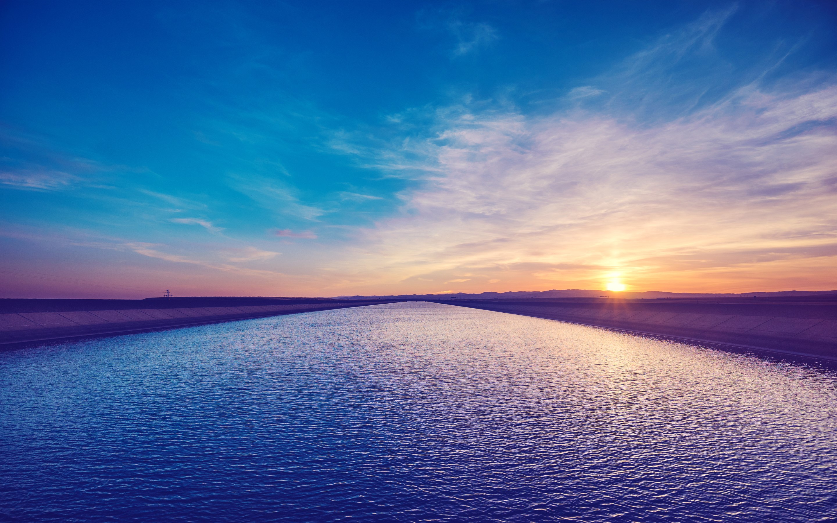 Sunset over a wide canal with blue sky HD Wallpaper