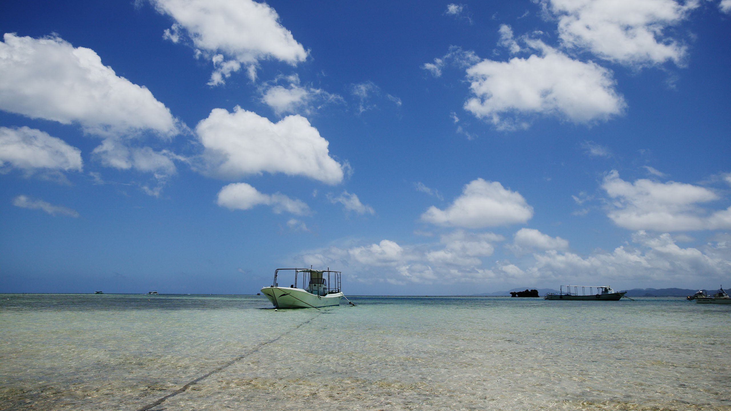 Boats on a clear tropical sea under a blue sky HD Wallpaper