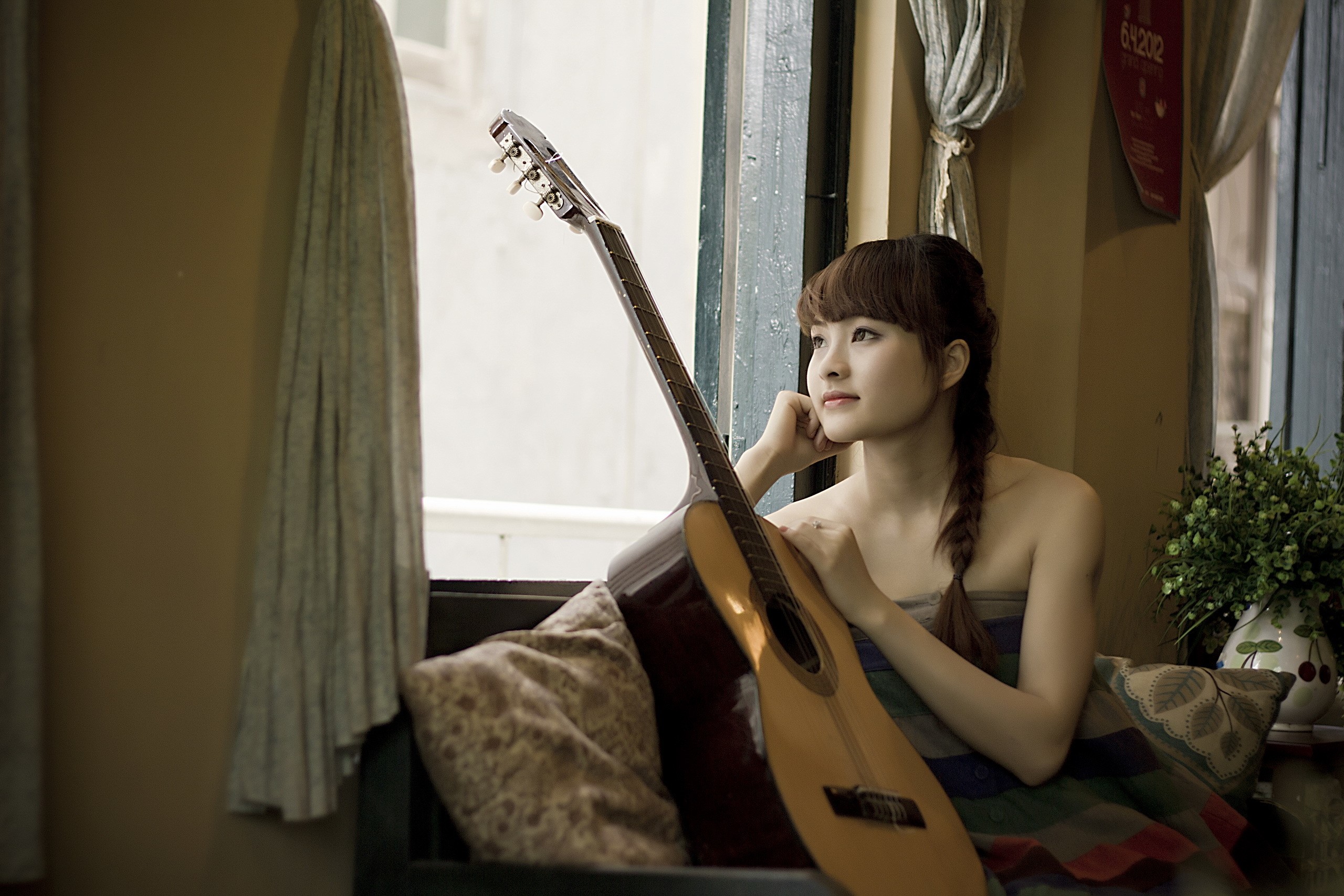 Asian woman with guitar by window HD Wallpaper