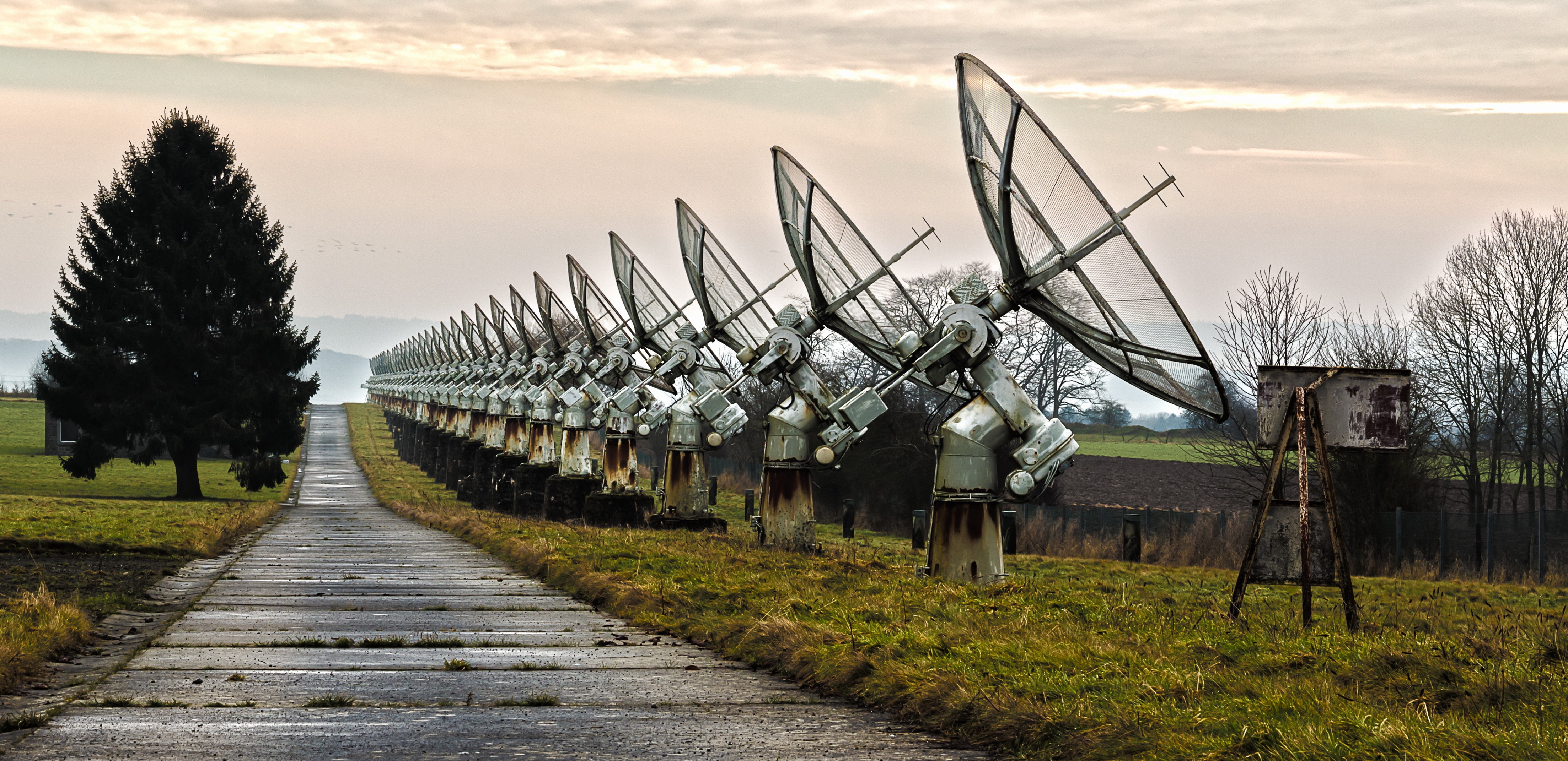 Array of satellite dishes on a road HD Wallpaper